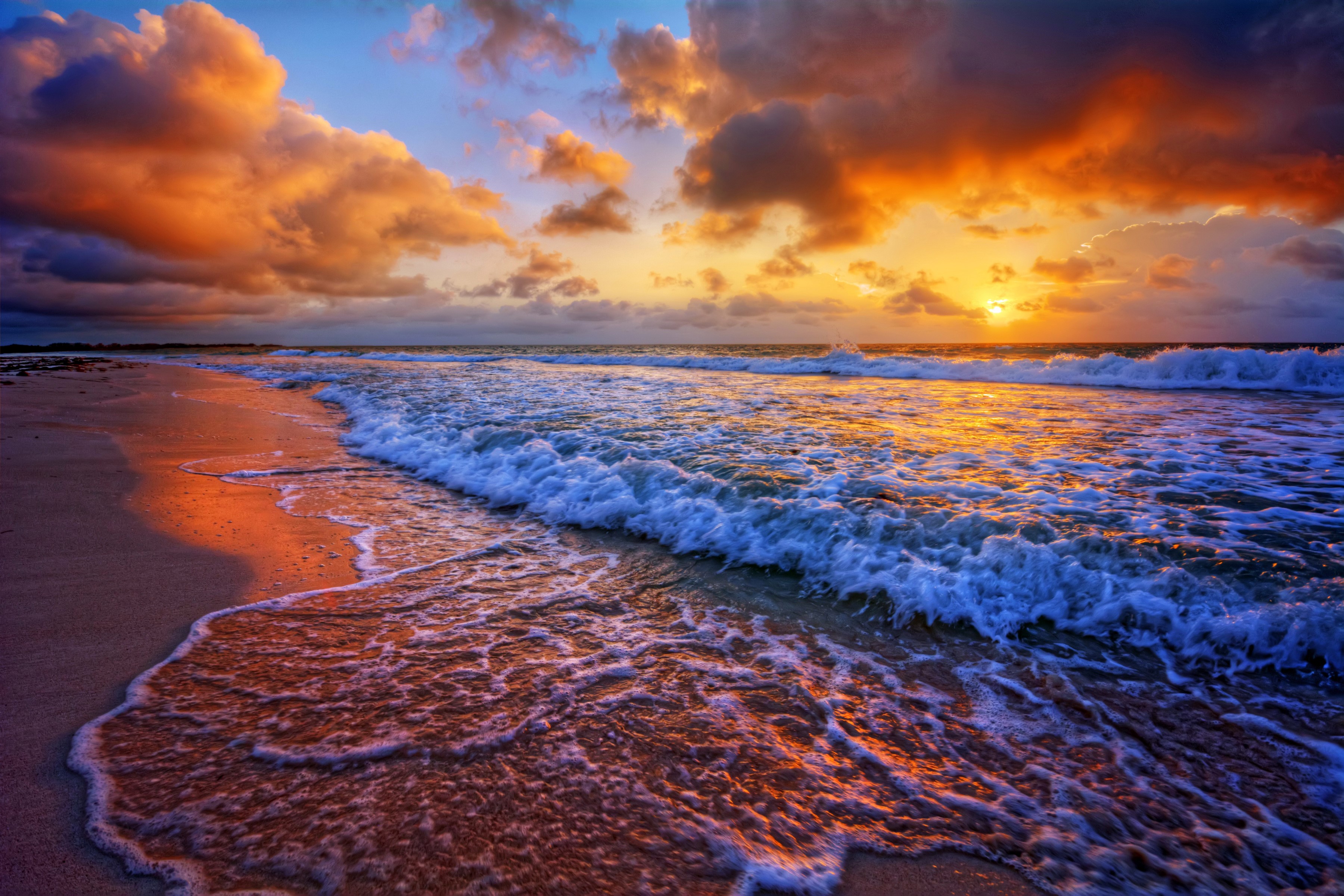 Sunset over the ocean with waves on the beach HD Wallpaper