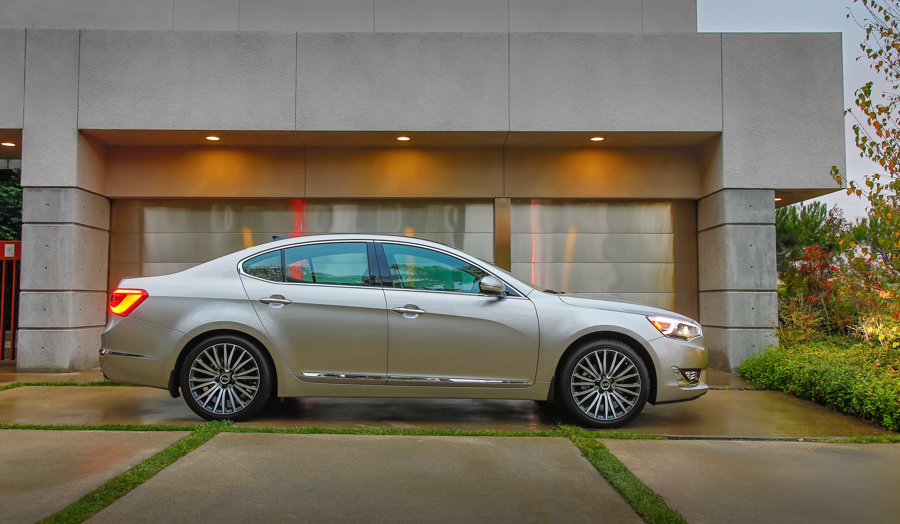 Silver 2014 Kia Cadenza parked in front of a modern garage HD Wallpaper