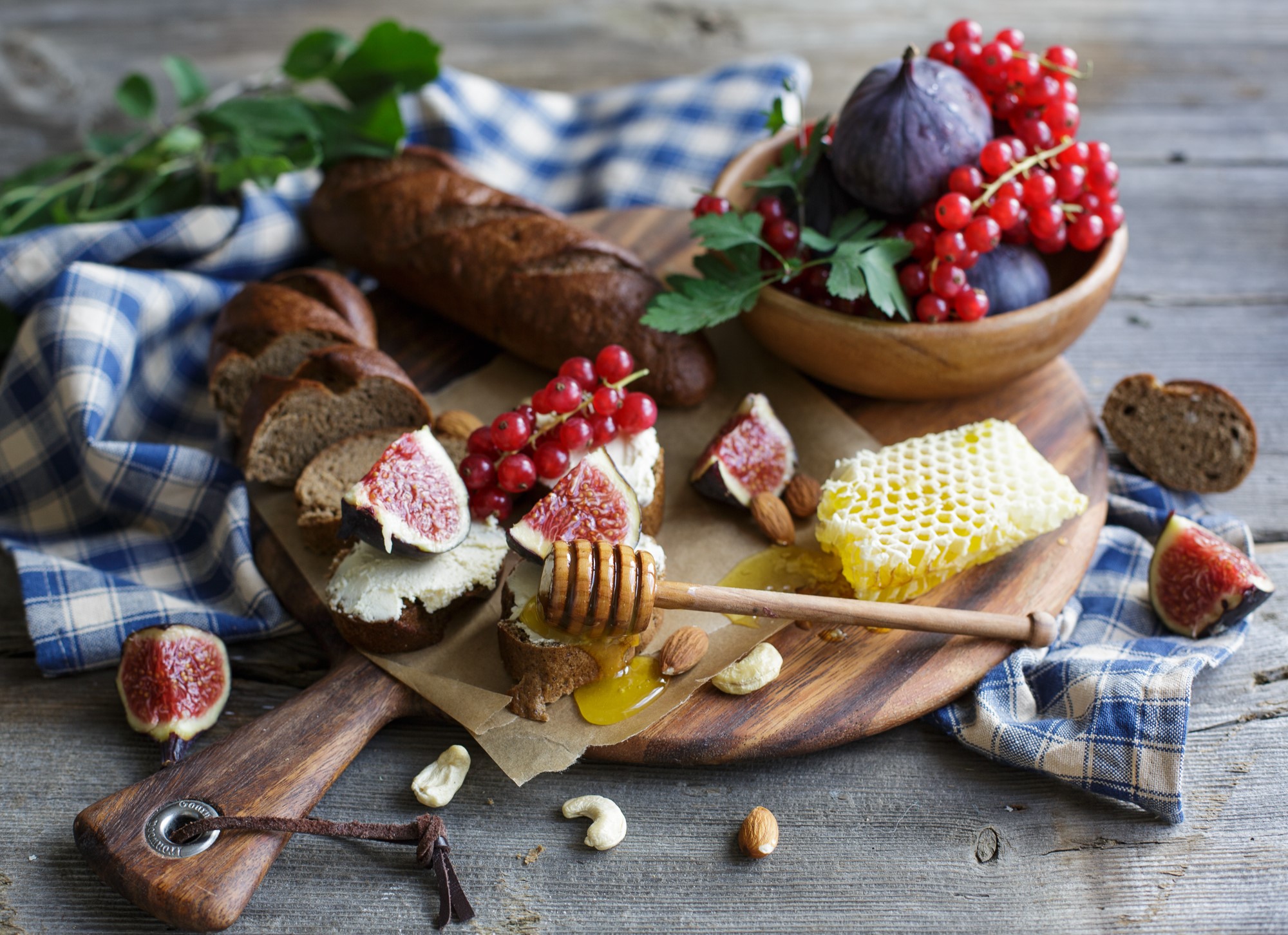 Bread, figs, currants, honeycomb, and nuts on a wooden board HD Wallpaper
