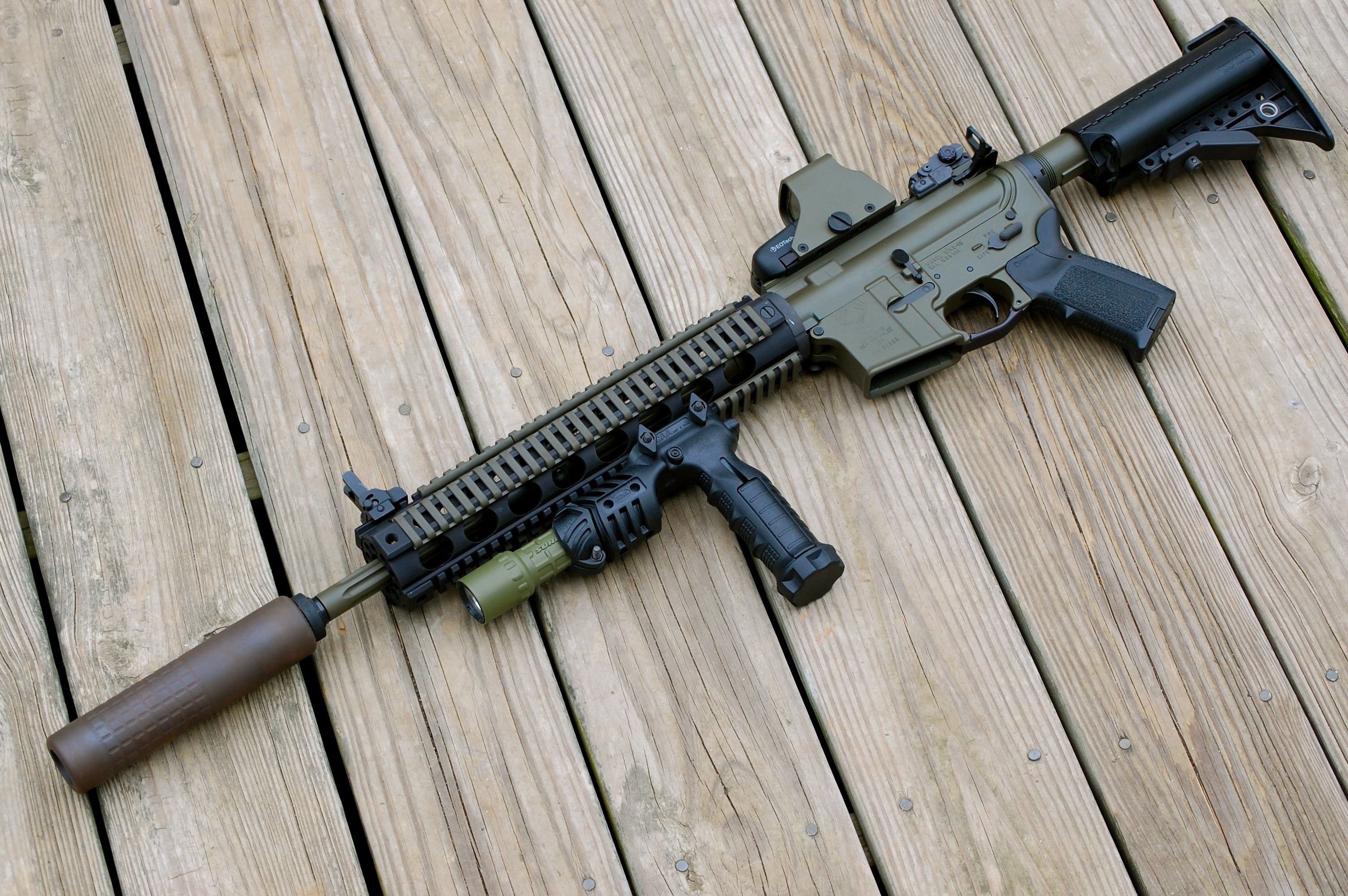 STAG-15 rifle with accessories on wooden deck HD Wallpaper
