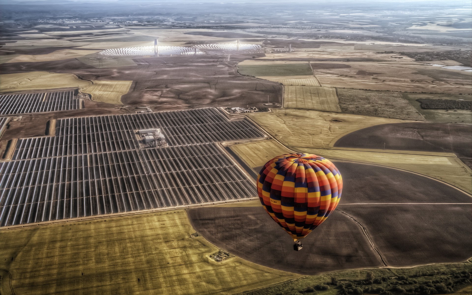 Hot air balloon over solar farm and fields HD Wallpaper