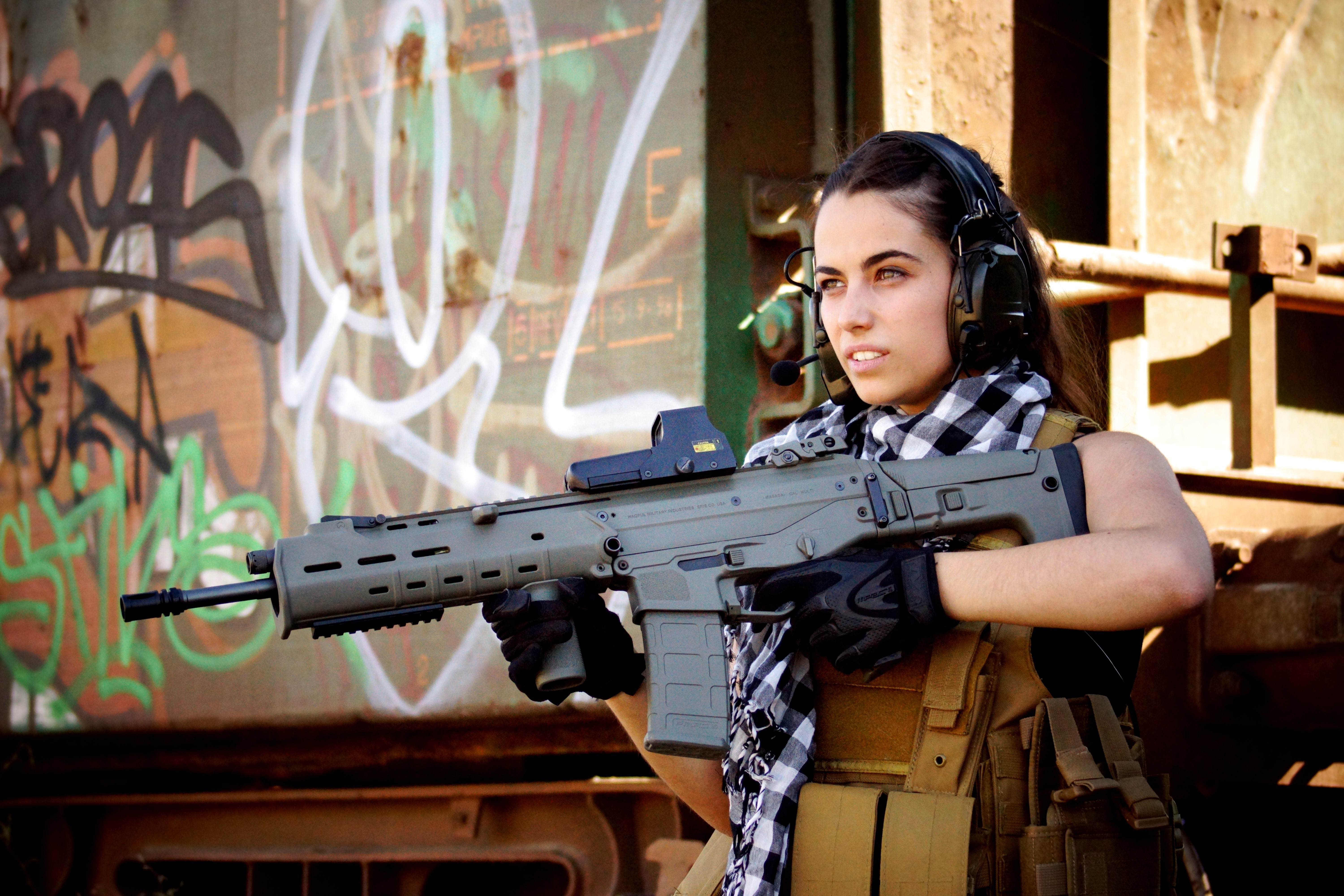 Woman with assault rifle and headphones HD Wallpaper