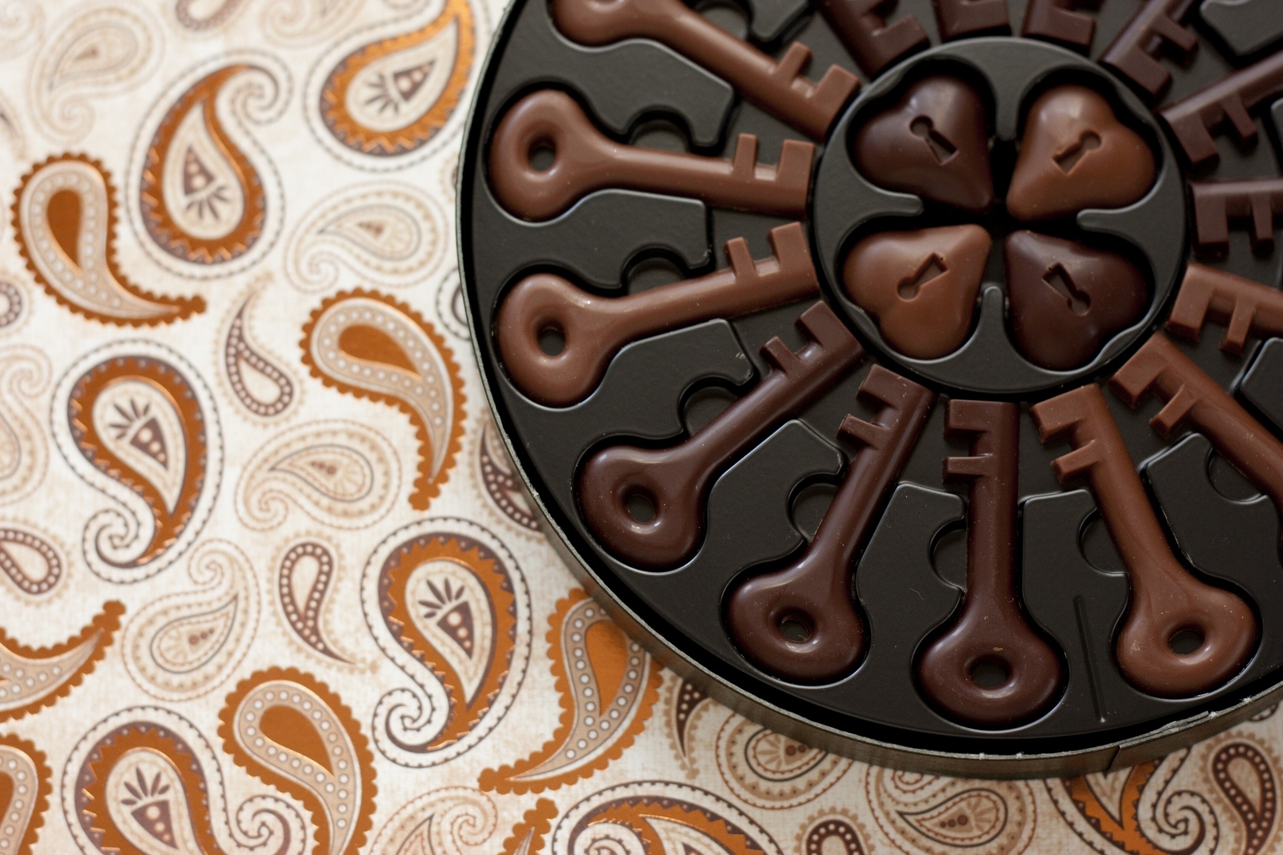 Chocolate key candies in a box on a paisley background HD Wallpaper