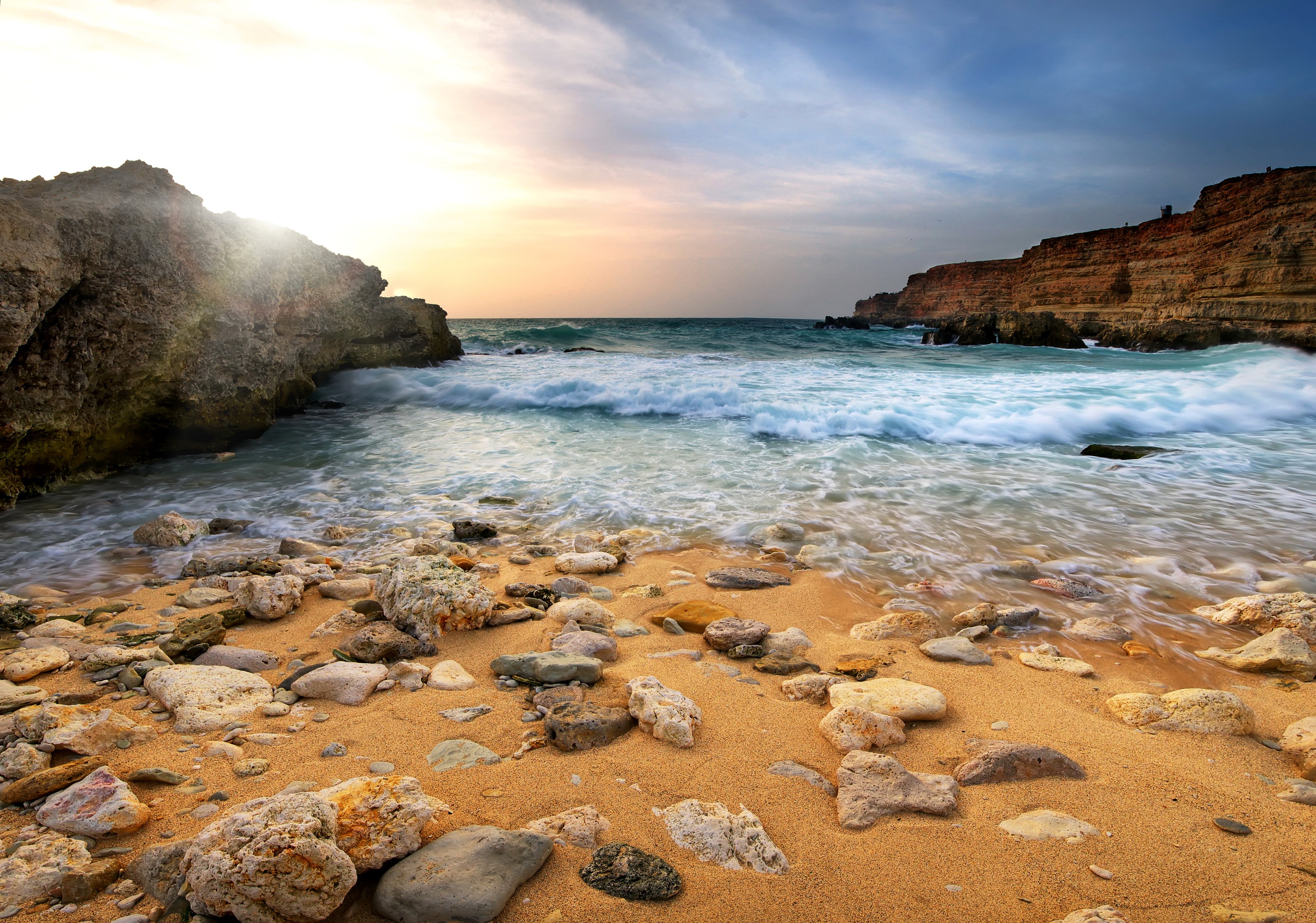 Rocky beach with waves crashing on shore at sunset HD Wallpaper