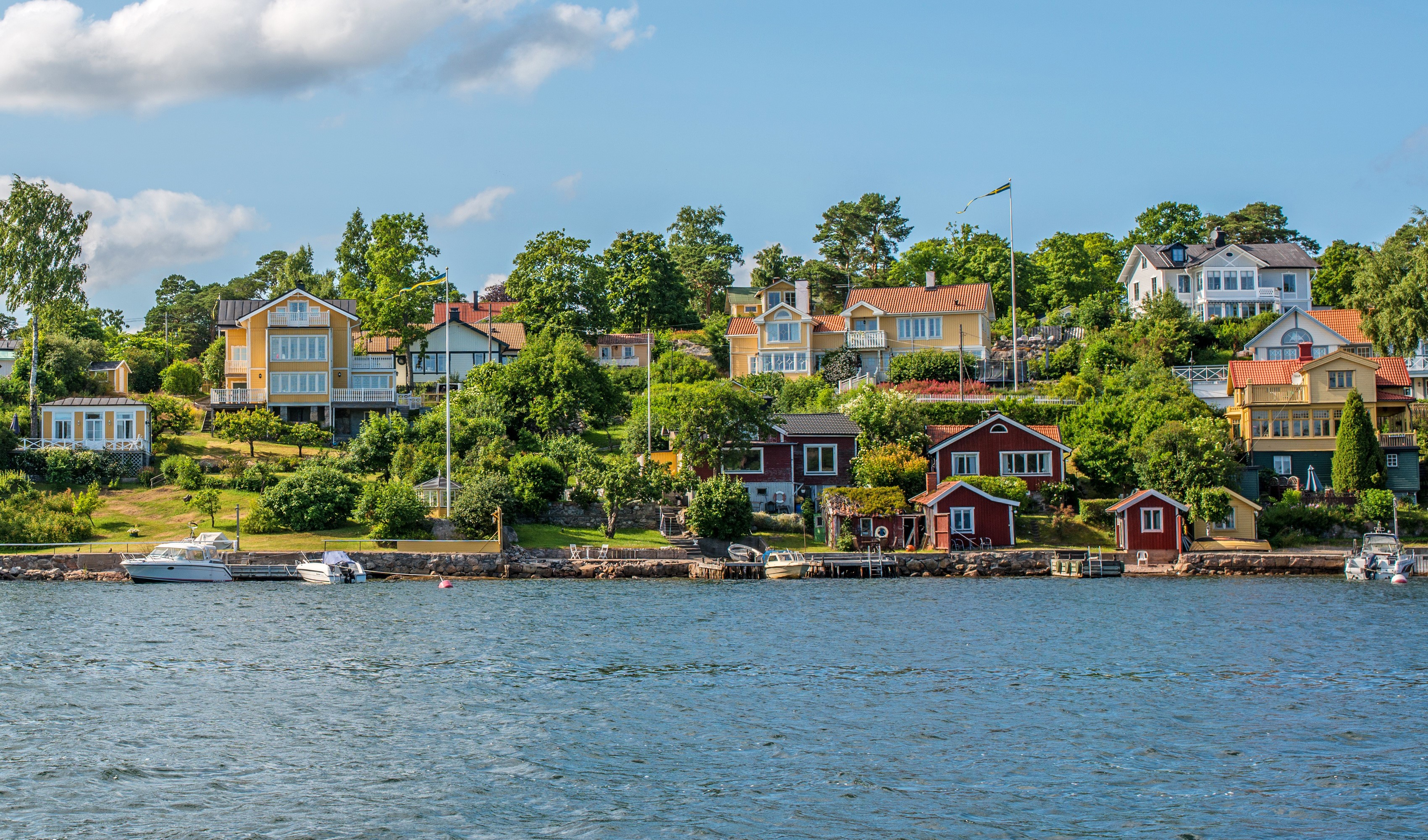 Houses on a hill overlooking the water in Sweden HD Wallpaper