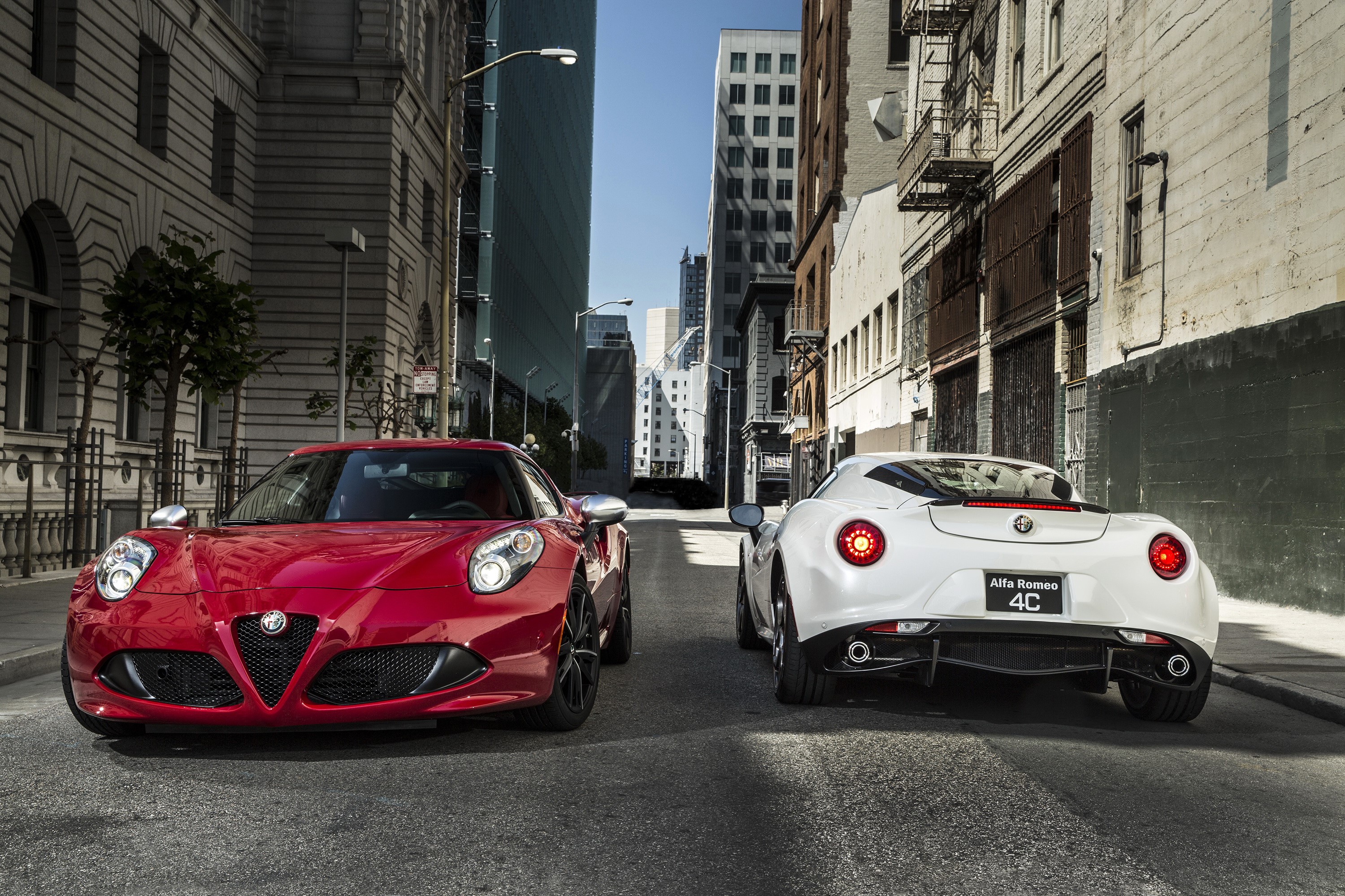 Two Alfa Romeo 4C cars on a city street HD Wallpaper