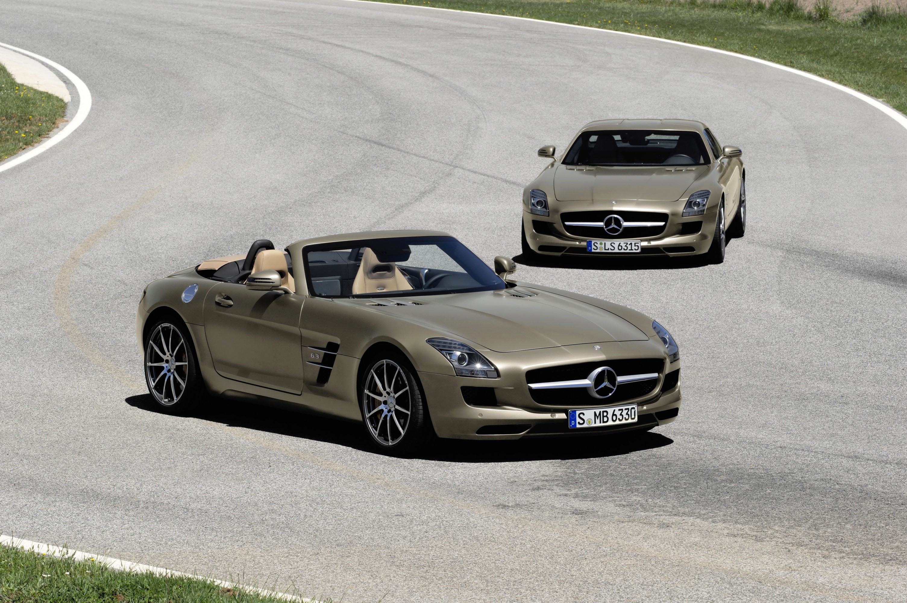 Two Mercedes-Benz SLS AMG roadsters on a road HD Wallpaper