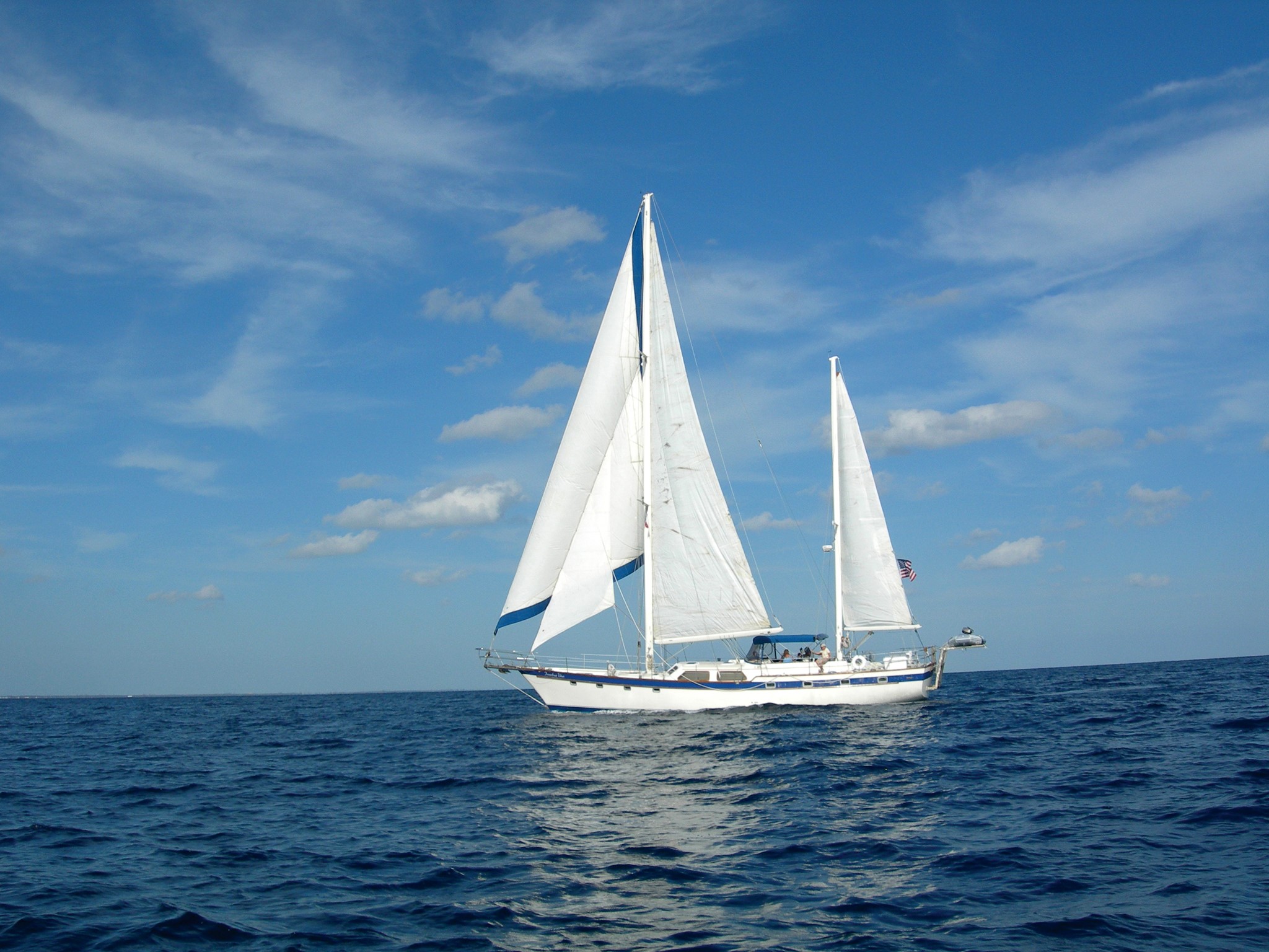 Sailboat sailing on the ocean under a cloudy sky HD Wallpaper
