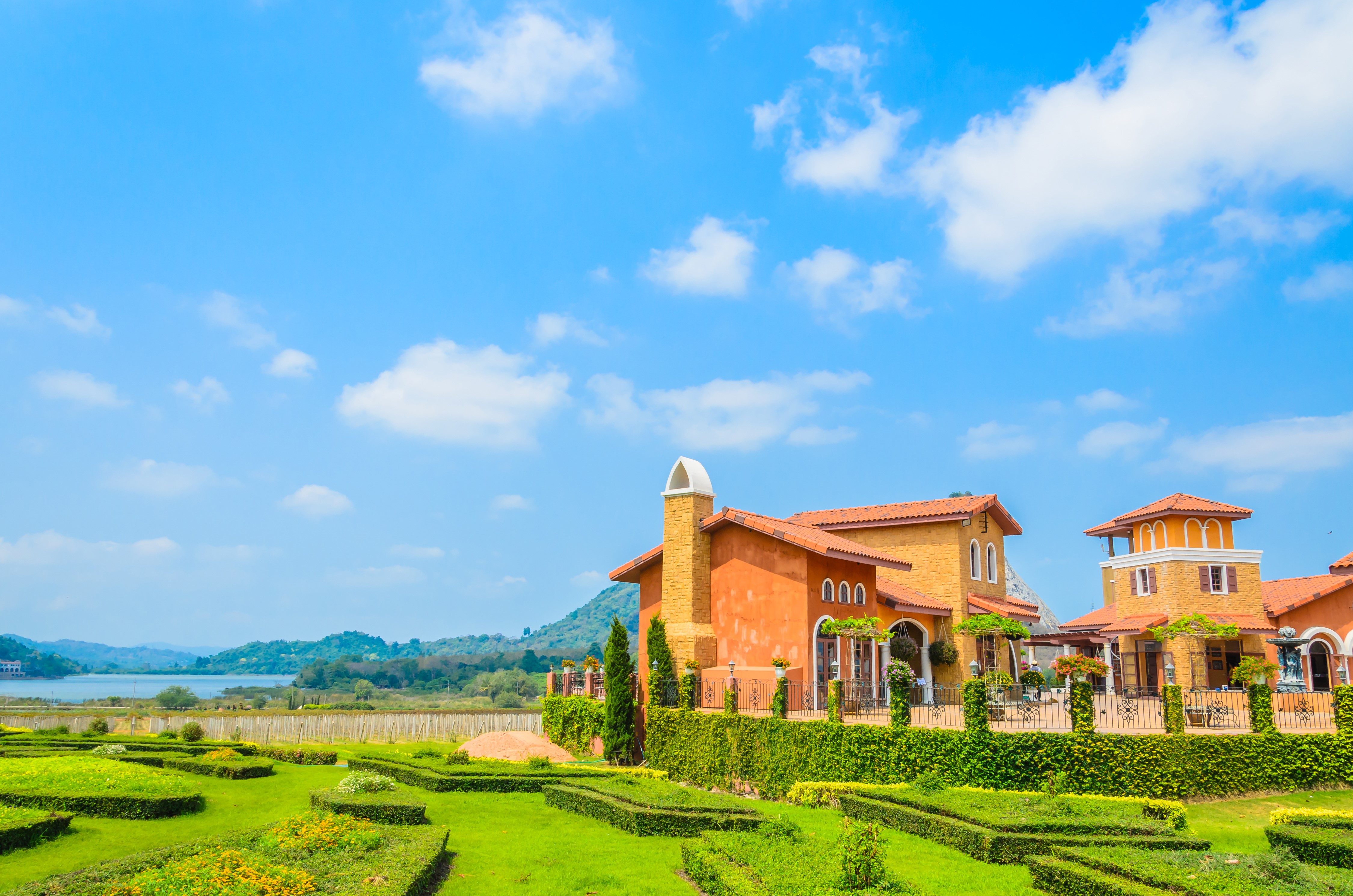 Italian-style houses with manicured gardens and a lake HD Wallpaper