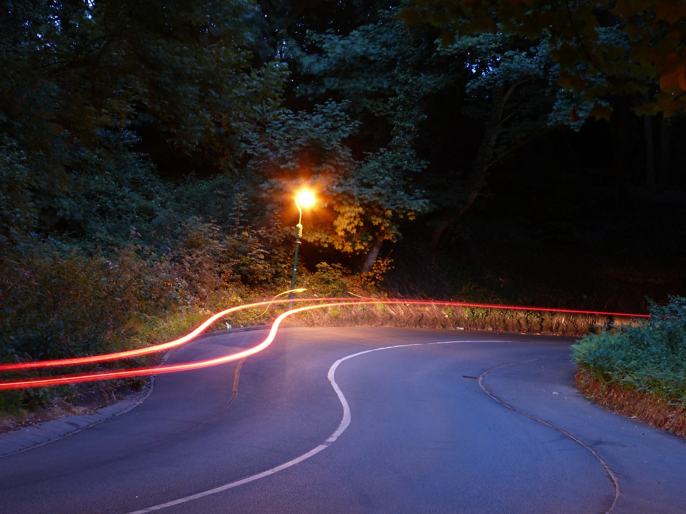 Road with light trails and street light at night HD Wallpaper