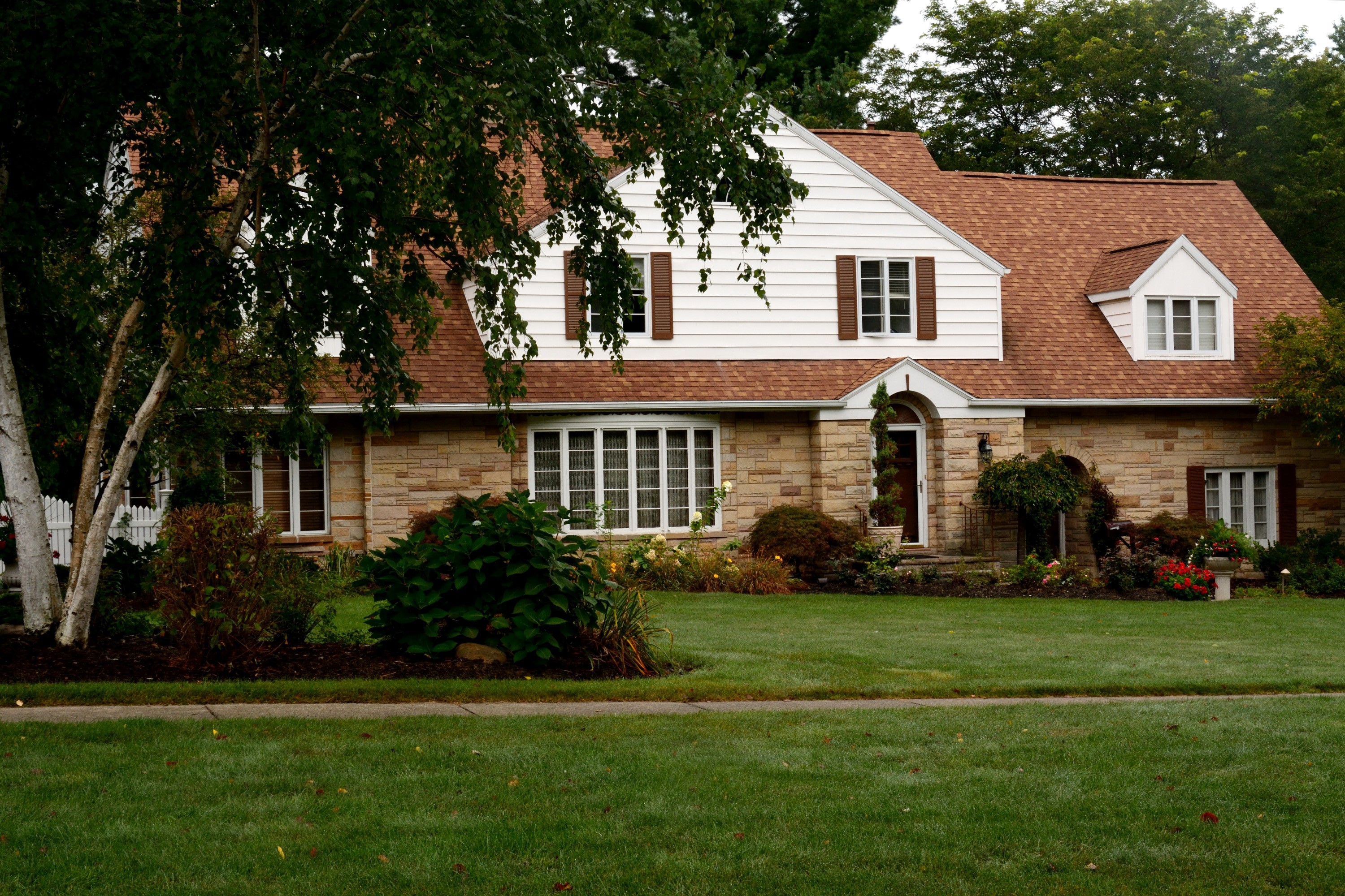 Stone and white siding house with red roof and lawn HD Wallpaper
