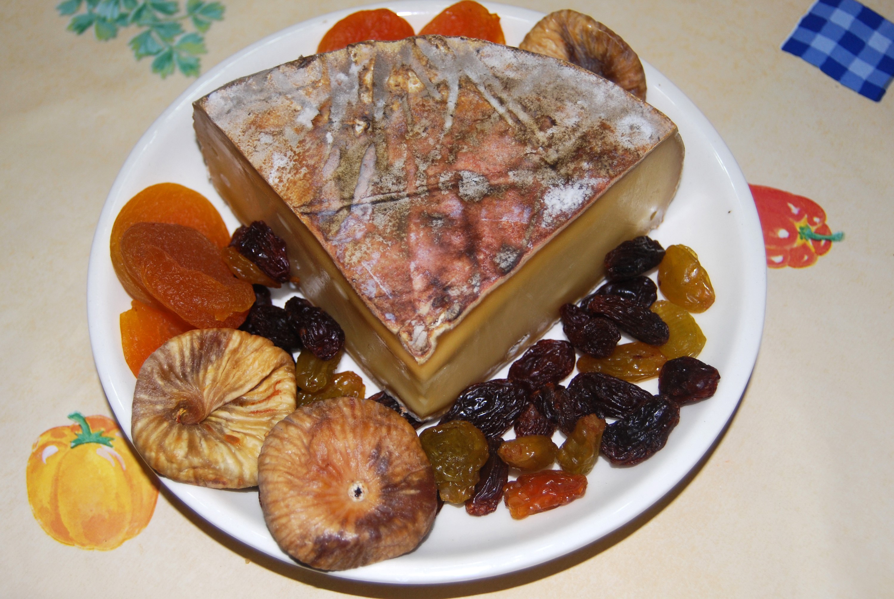 Cheese with dried fruits on a plate HD Wallpaper