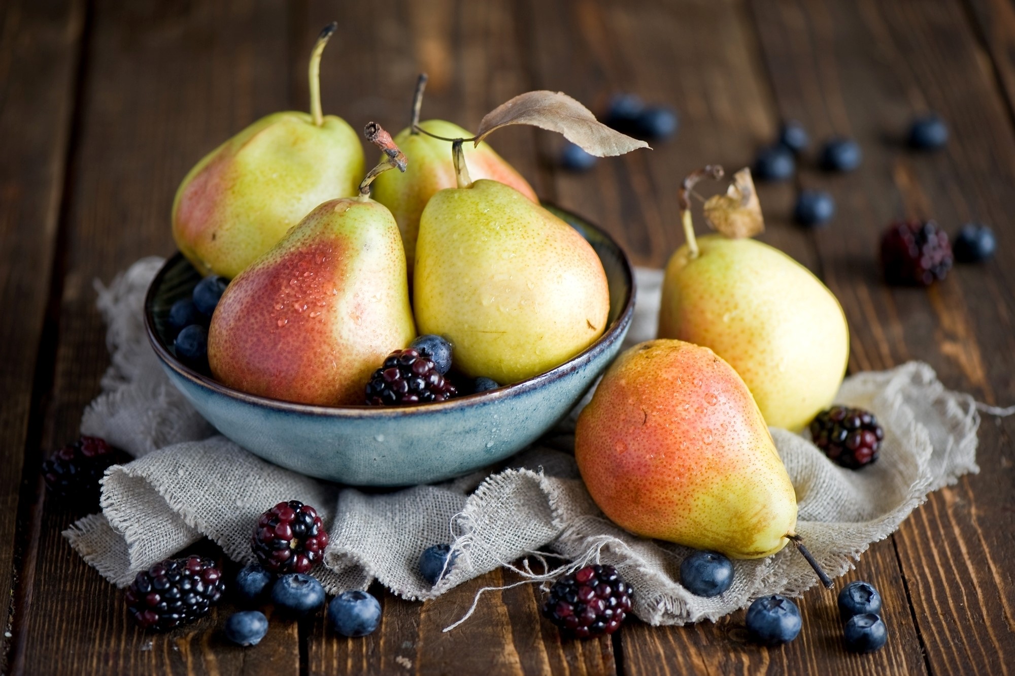 Pears and berries in a bowl on a wooden table HD Wallpaper