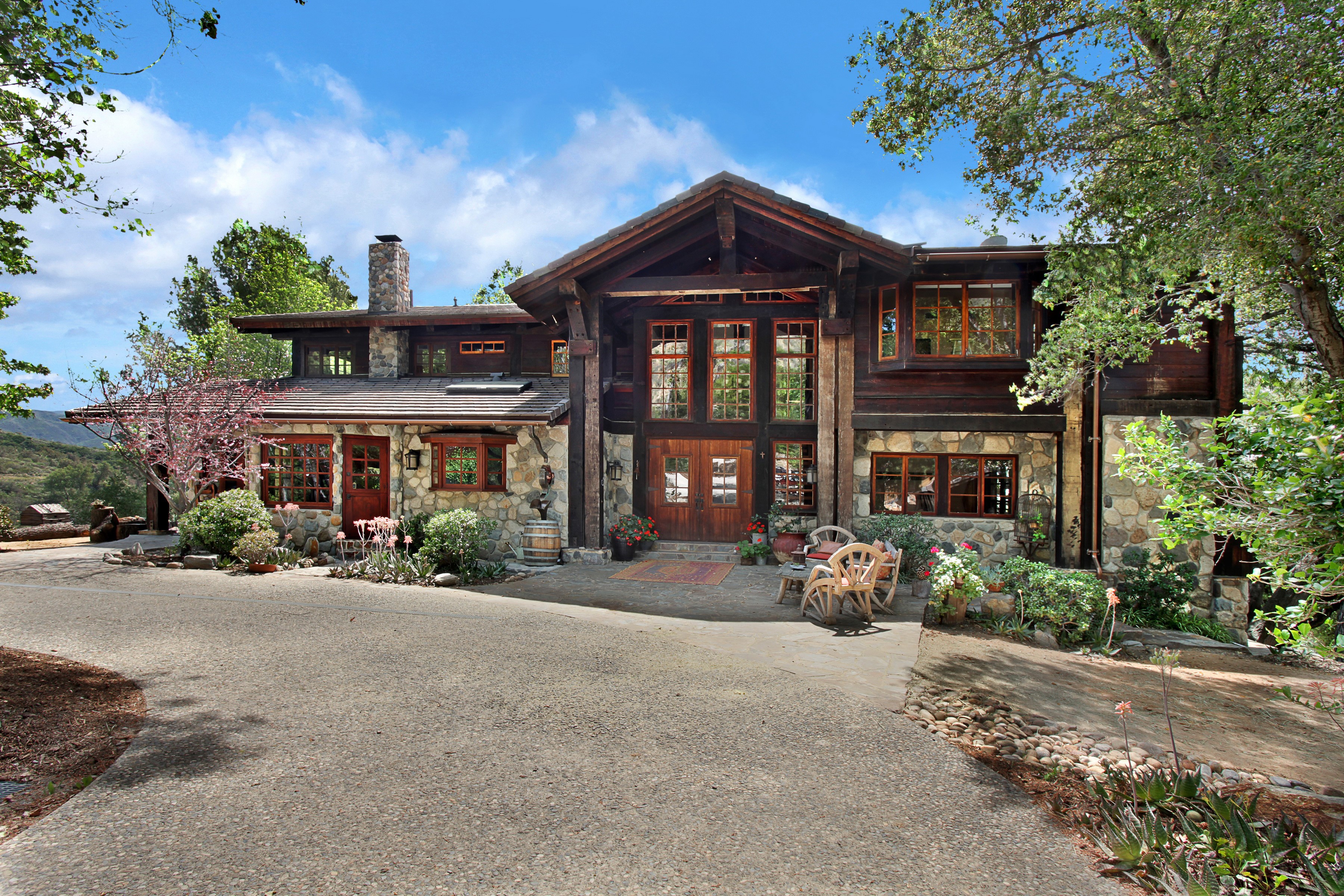 Rustic stone and wood mountain lodge with large windows HD Wallpaper