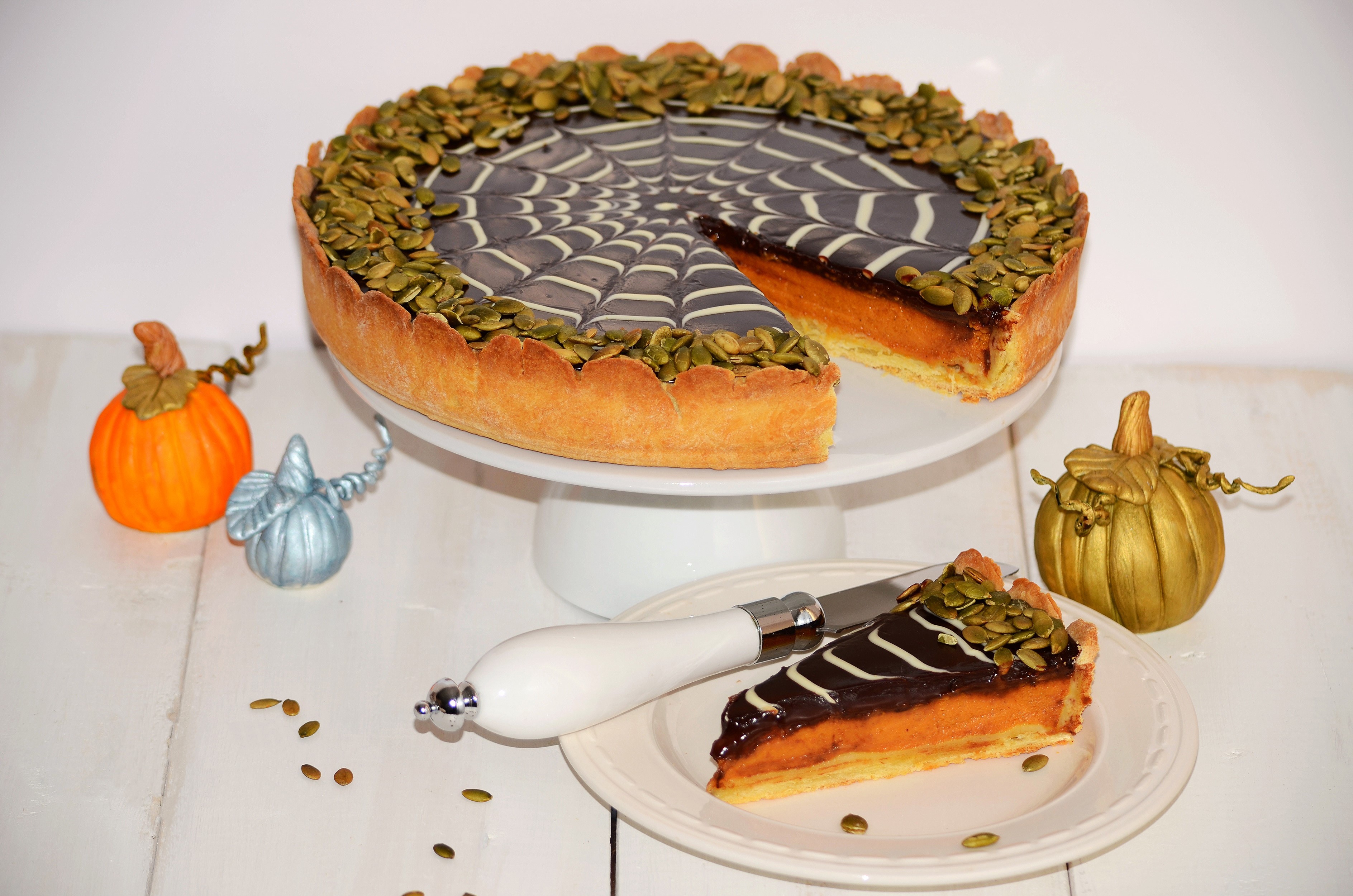 Pumpkin pie with spider web chocolate topping and pumpkin decorations HD Wallpaper