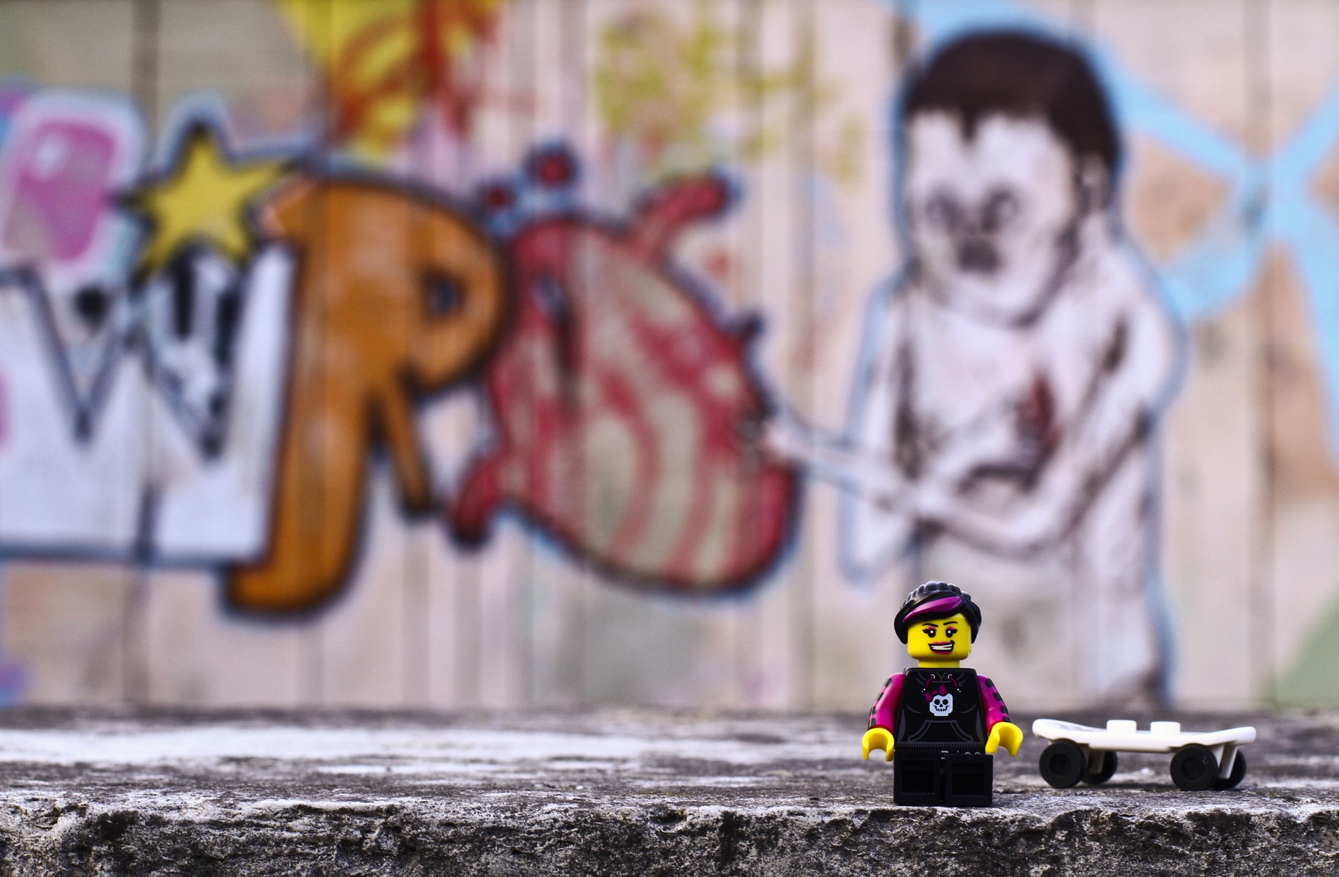 Lego figure with skateboard in front of graffiti wall HD Wallpaper