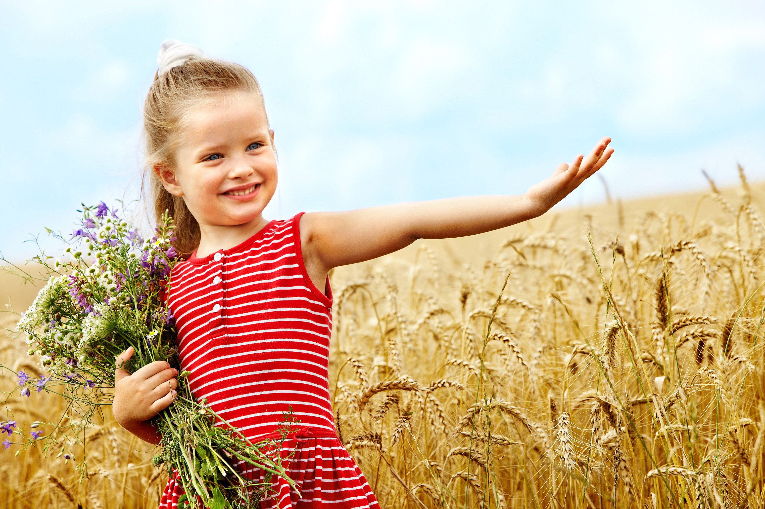 Girl in red dress holding flowers in a wheat field HD Wallpaper