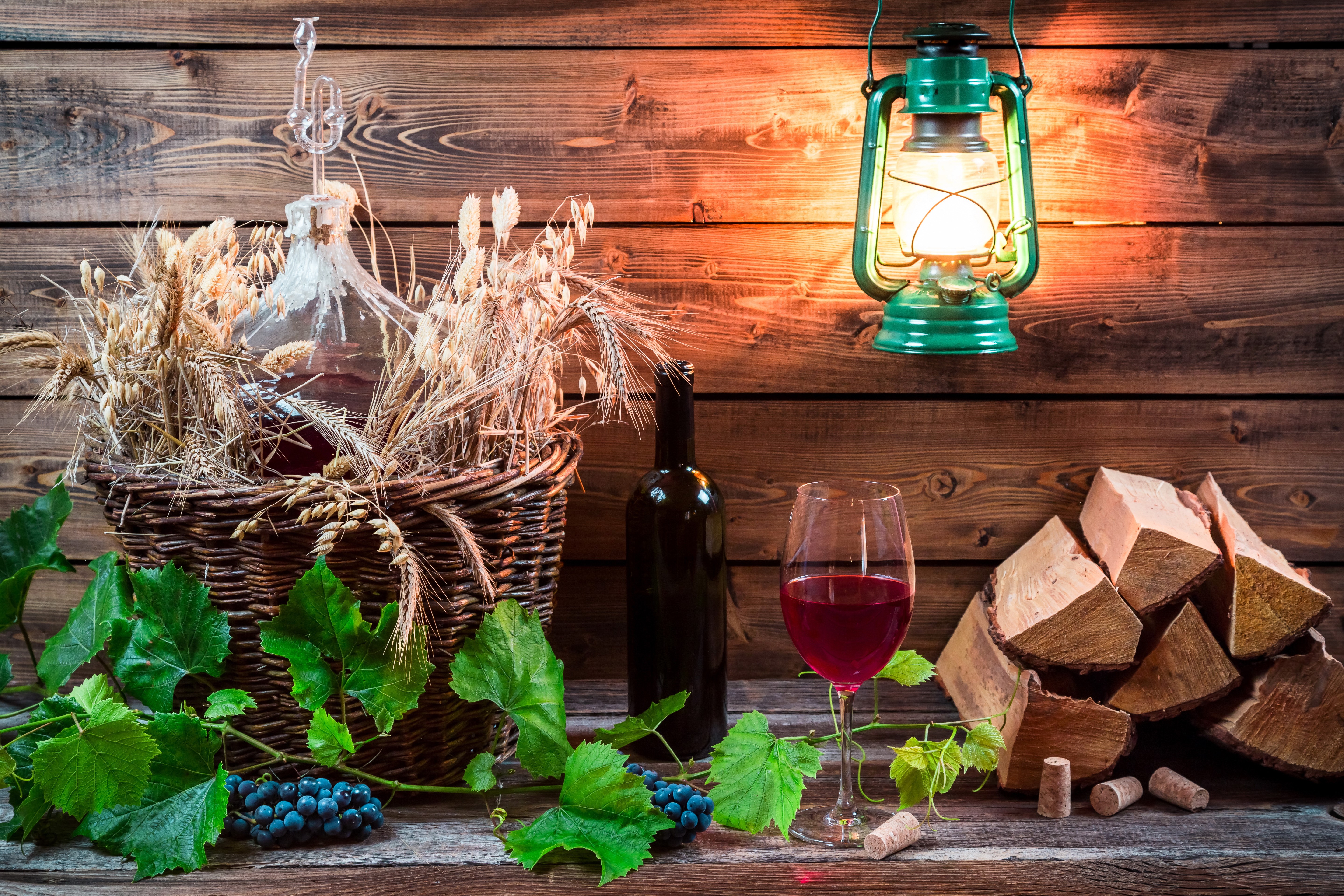 Still-life of wine, grapes, and wheat in a wicker basket with a kerosene lamp HD Wallpaper