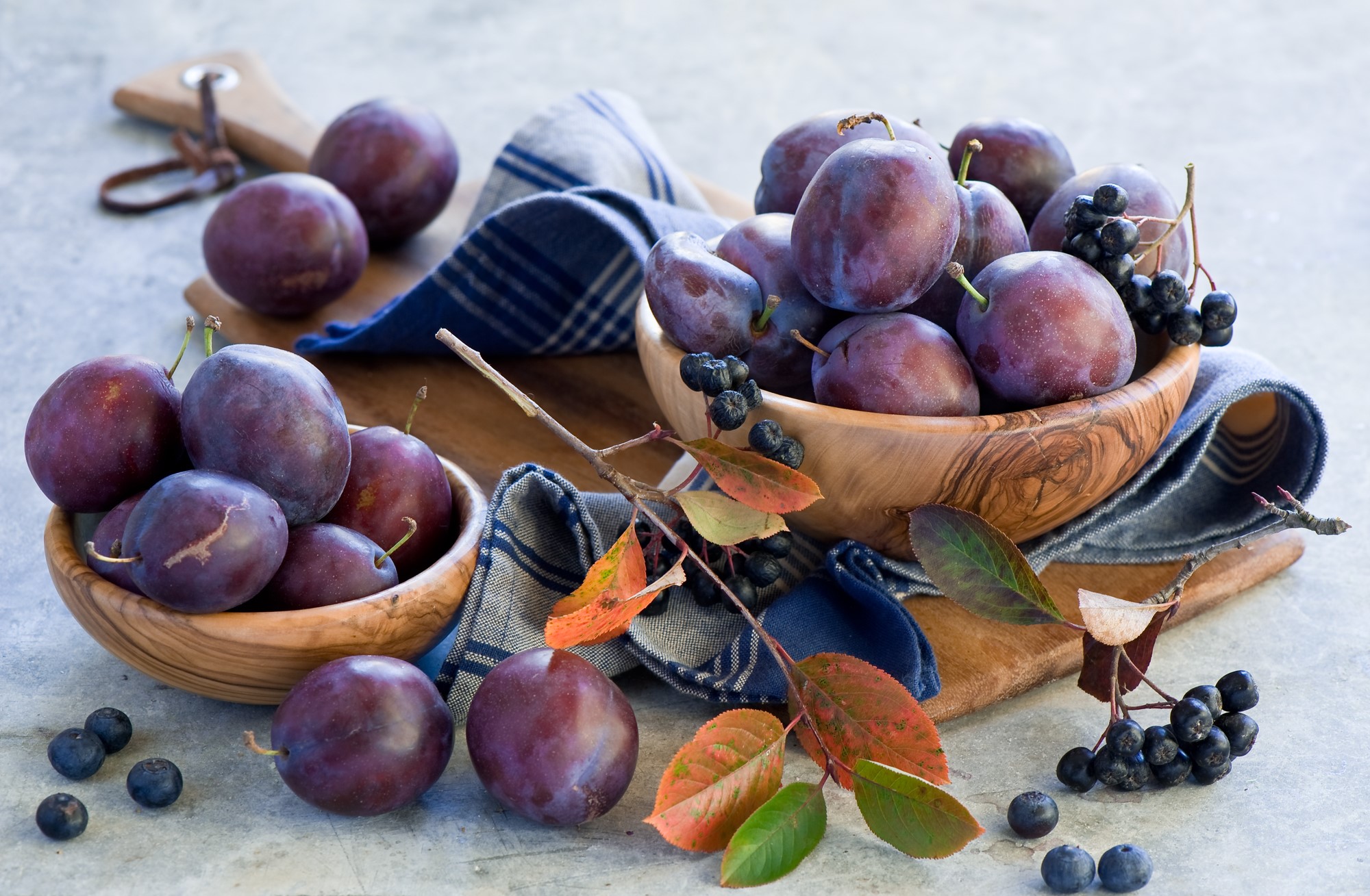 Plums and Aronia berries in wooden bowls HD Wallpaper