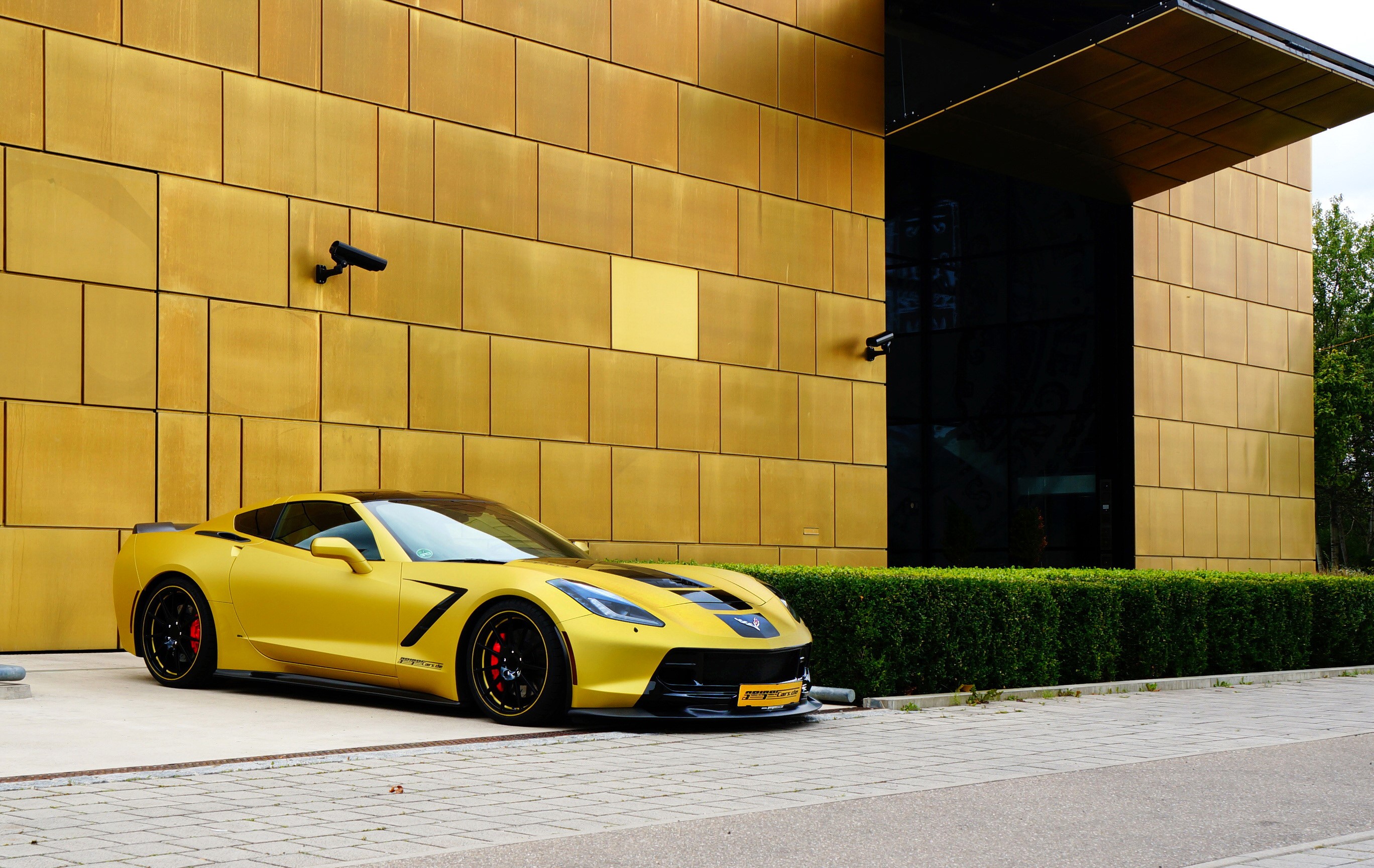 Yellow GeigerCars Corvette C7 Stingray parked by golden building HD Wallpaper