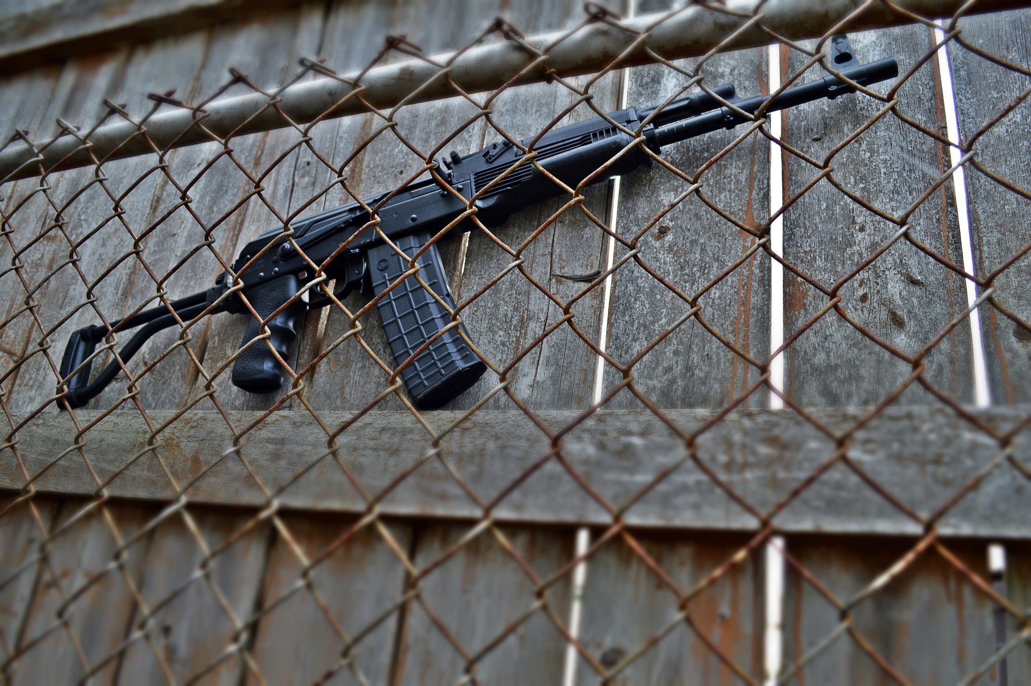 Saiga shotgun resting on a wooden fence HD Wallpaper