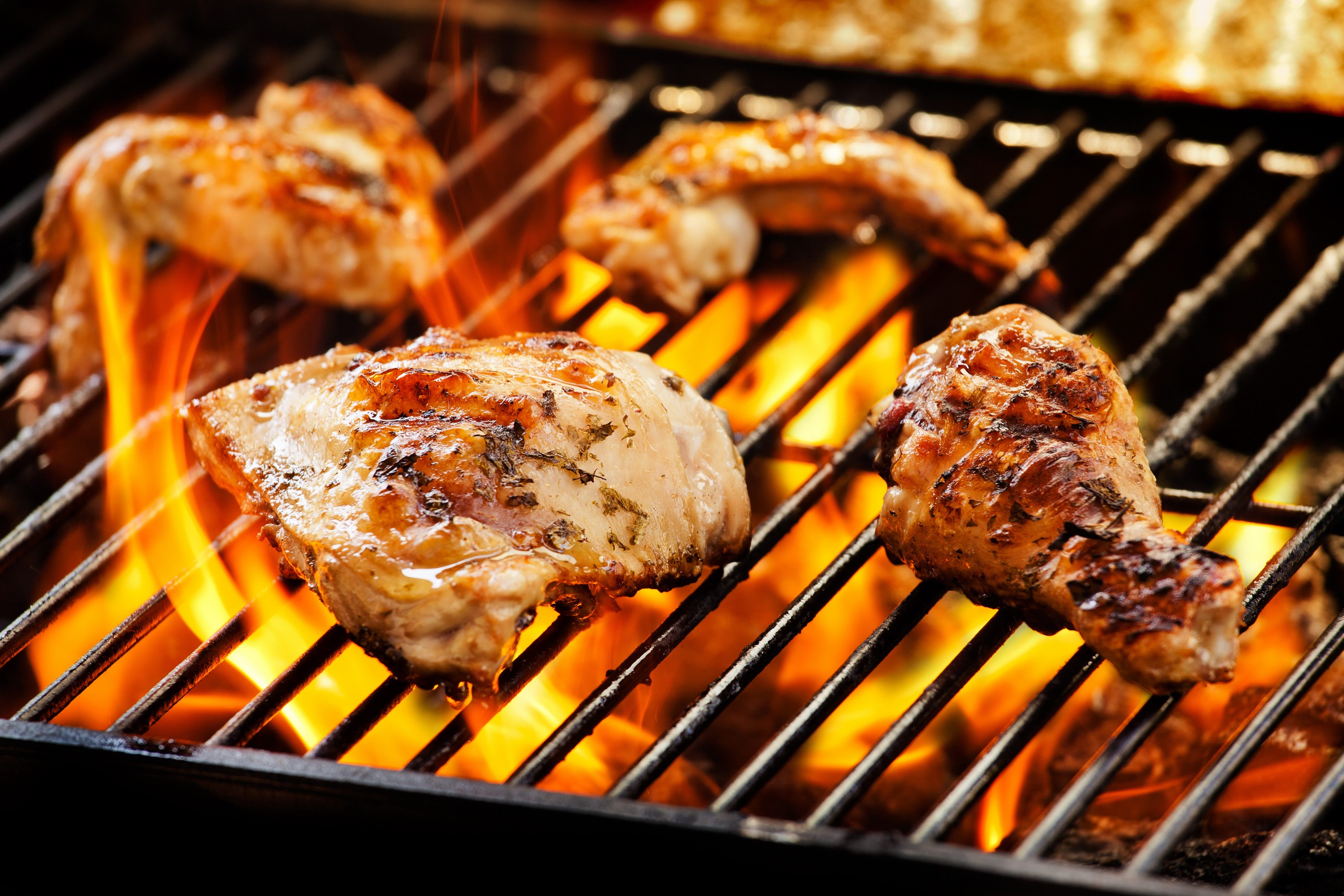 Chicken pieces cooking on a grill with flames HD Wallpaper