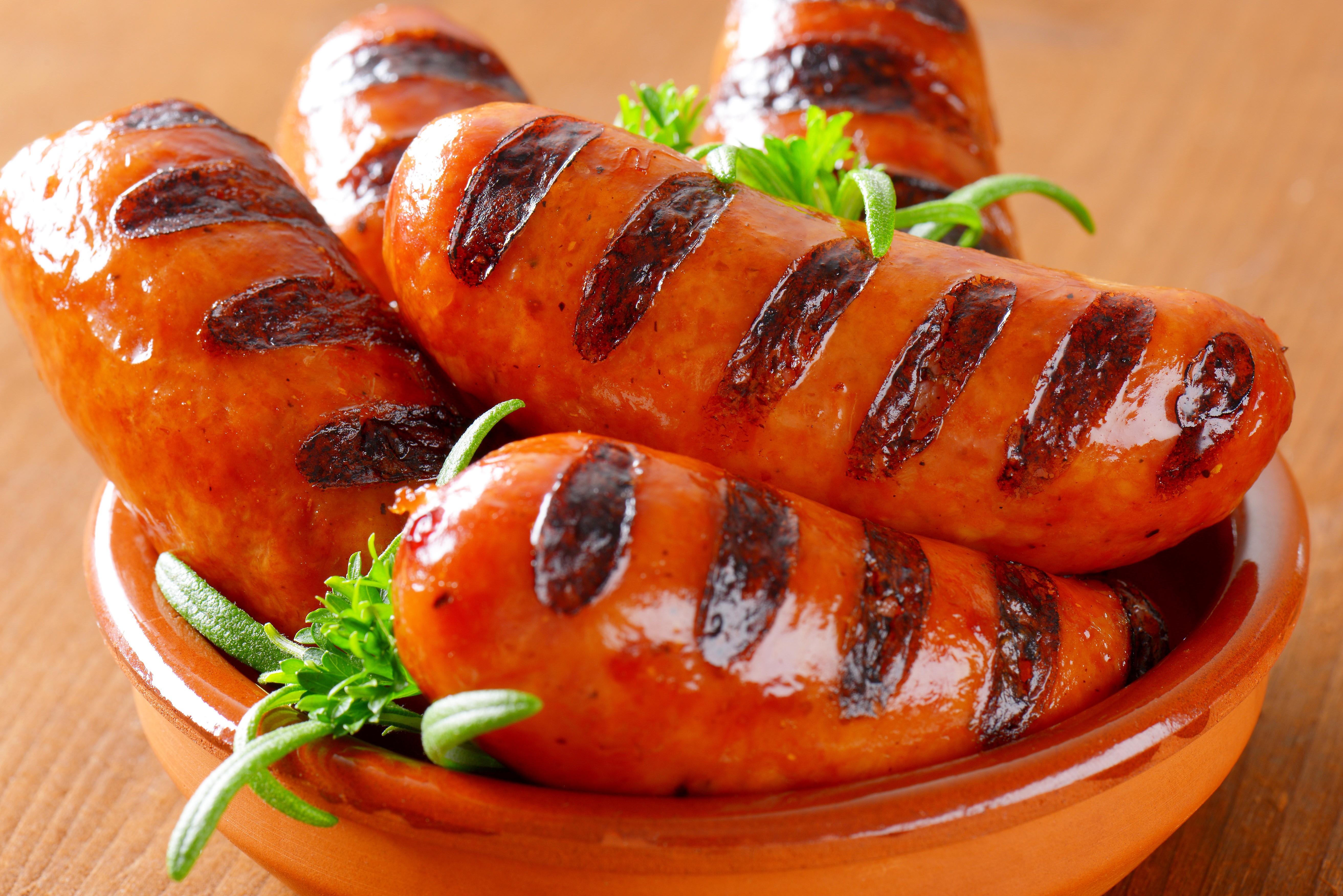 Grilled sausages in a bowl with herbs HD Wallpaper