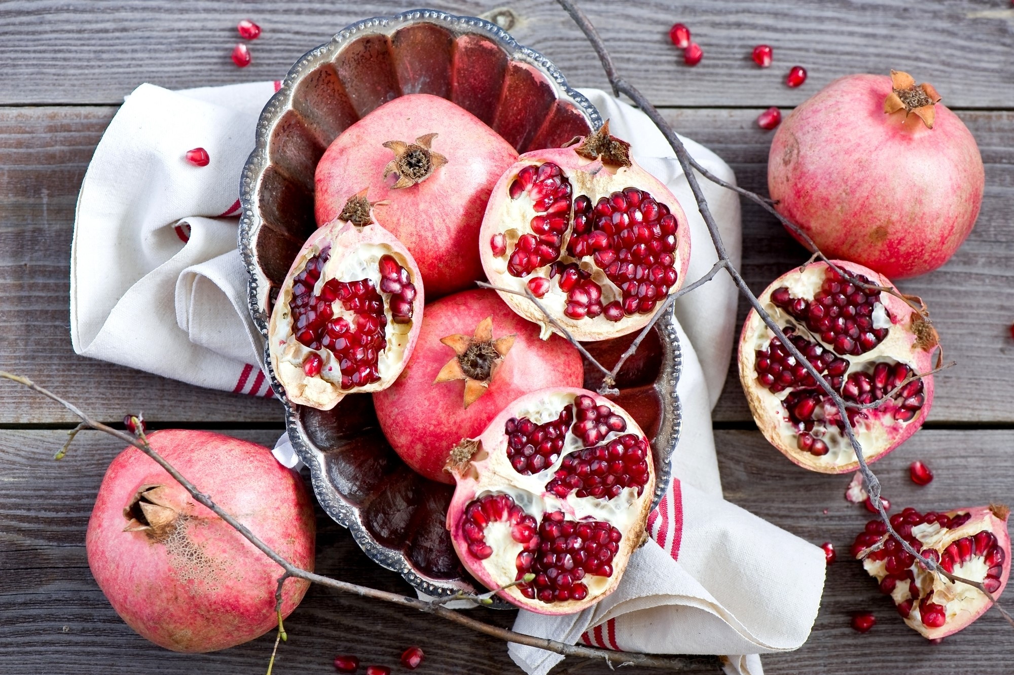 Pomegranates in a bowl on a wooden table HD Wallpaper