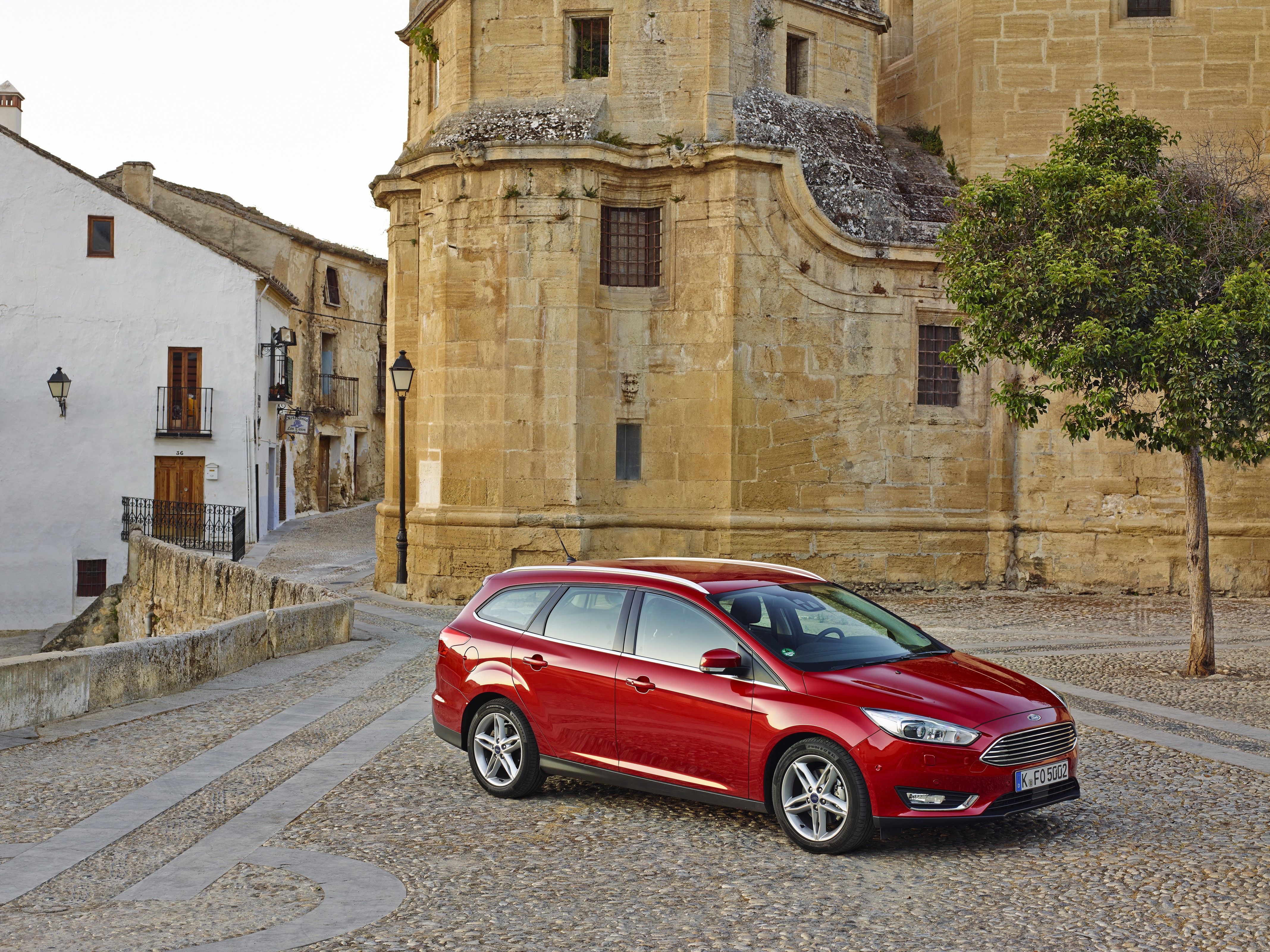 Red Ford Focus SW on cobblestone street in old town HD Wallpaper