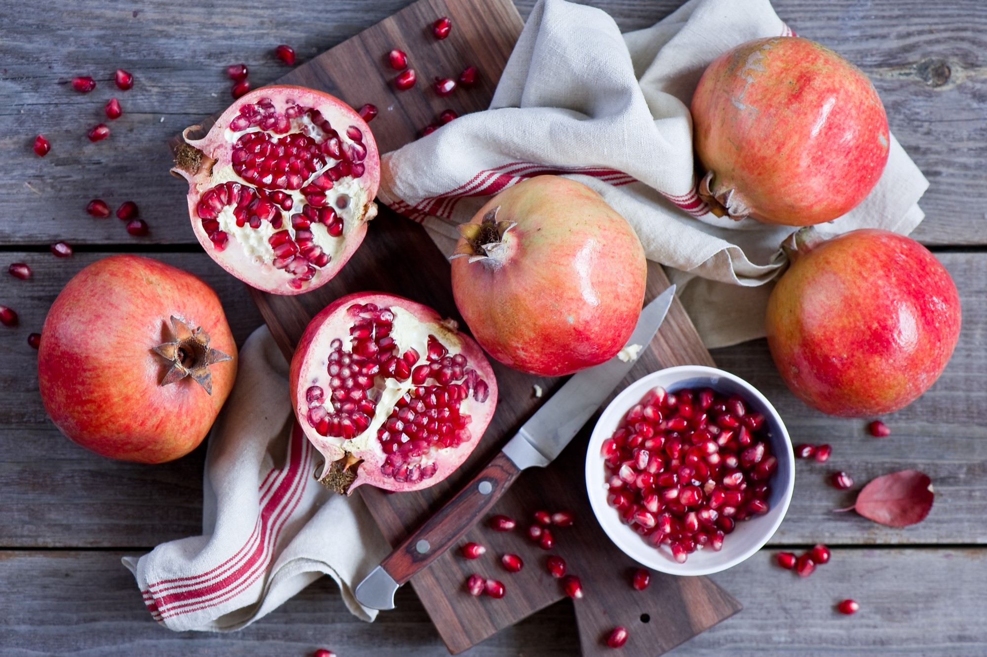 Pomegranates and knife on a wooden table HD Wallpaper