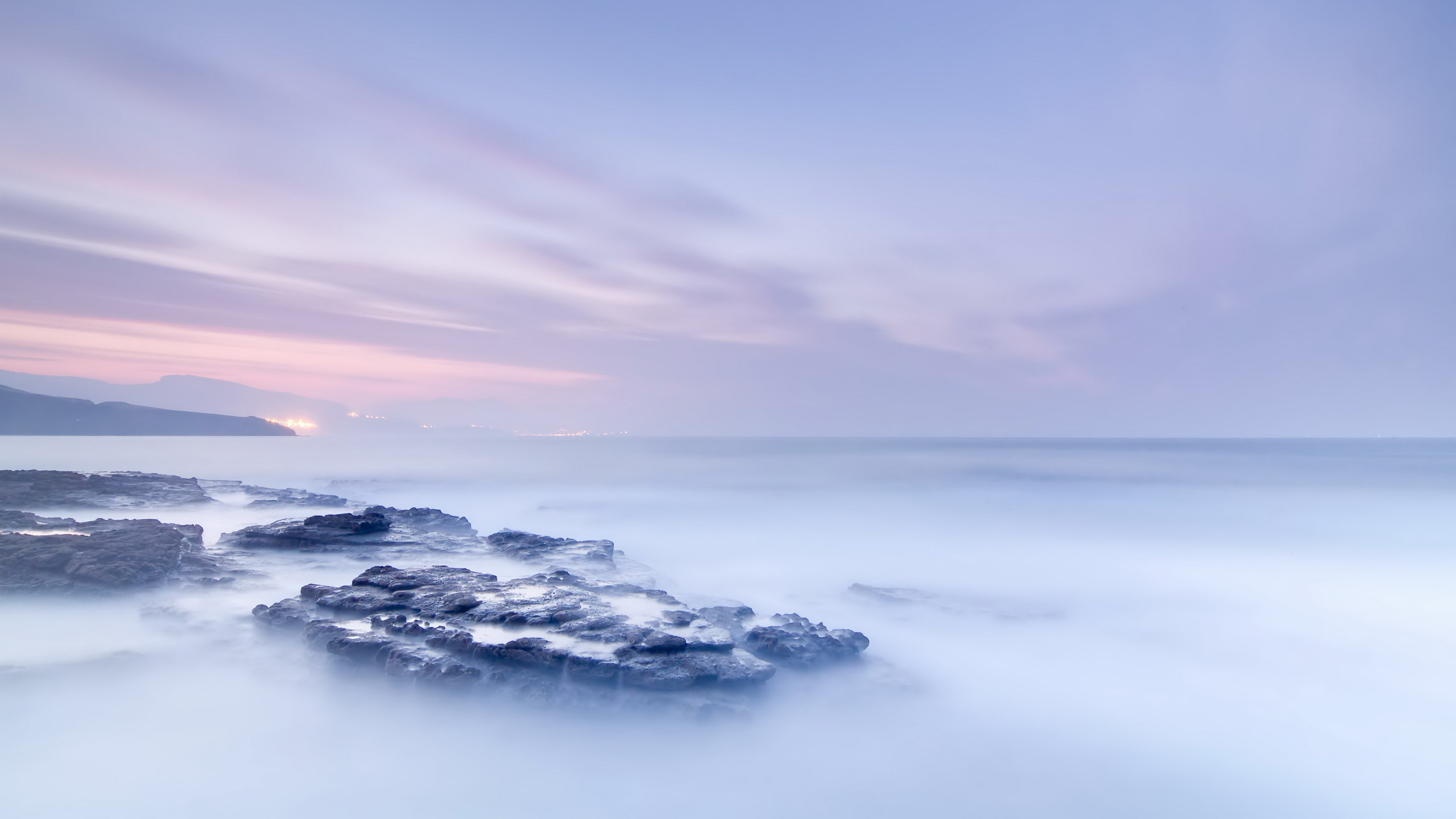 Rocky coastline with misty ocean and pastel sky HD Wallpaper