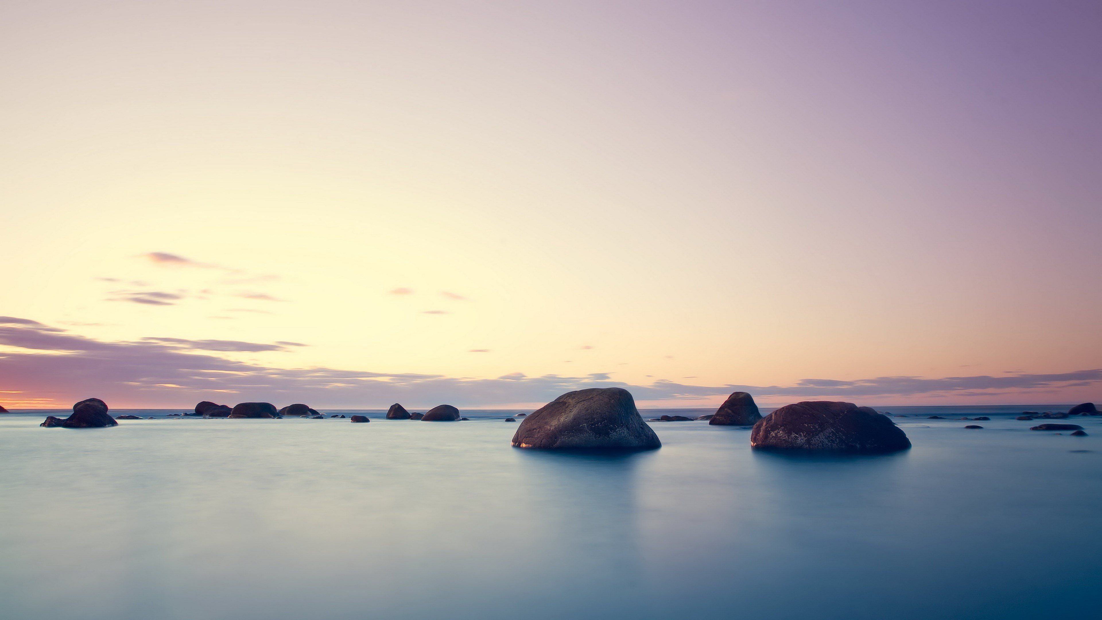 Rocks in the ocean at sunset HD Wallpaper
