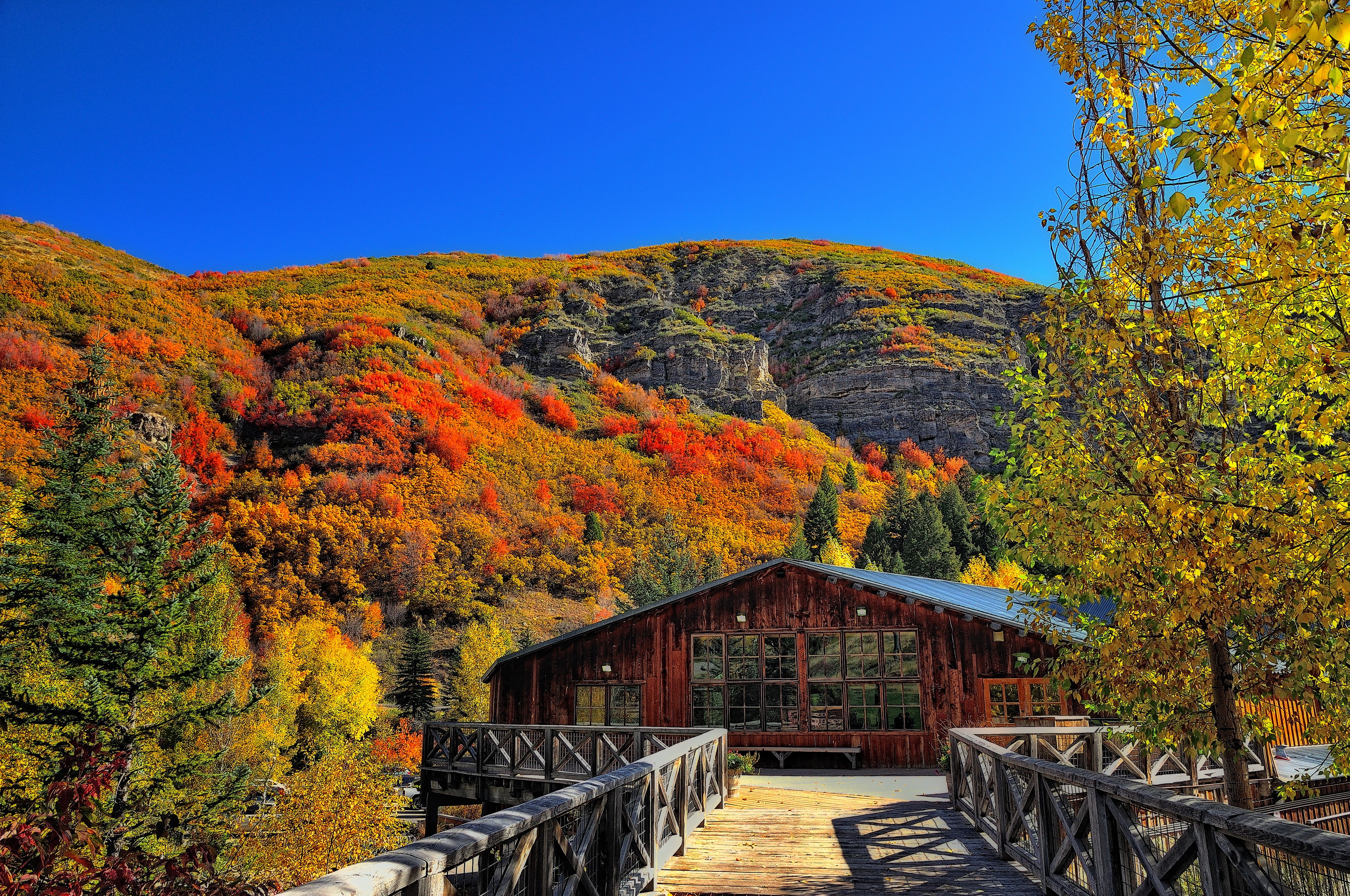 Wooden lodge and bridge in autumn mountains HD Wallpaper
