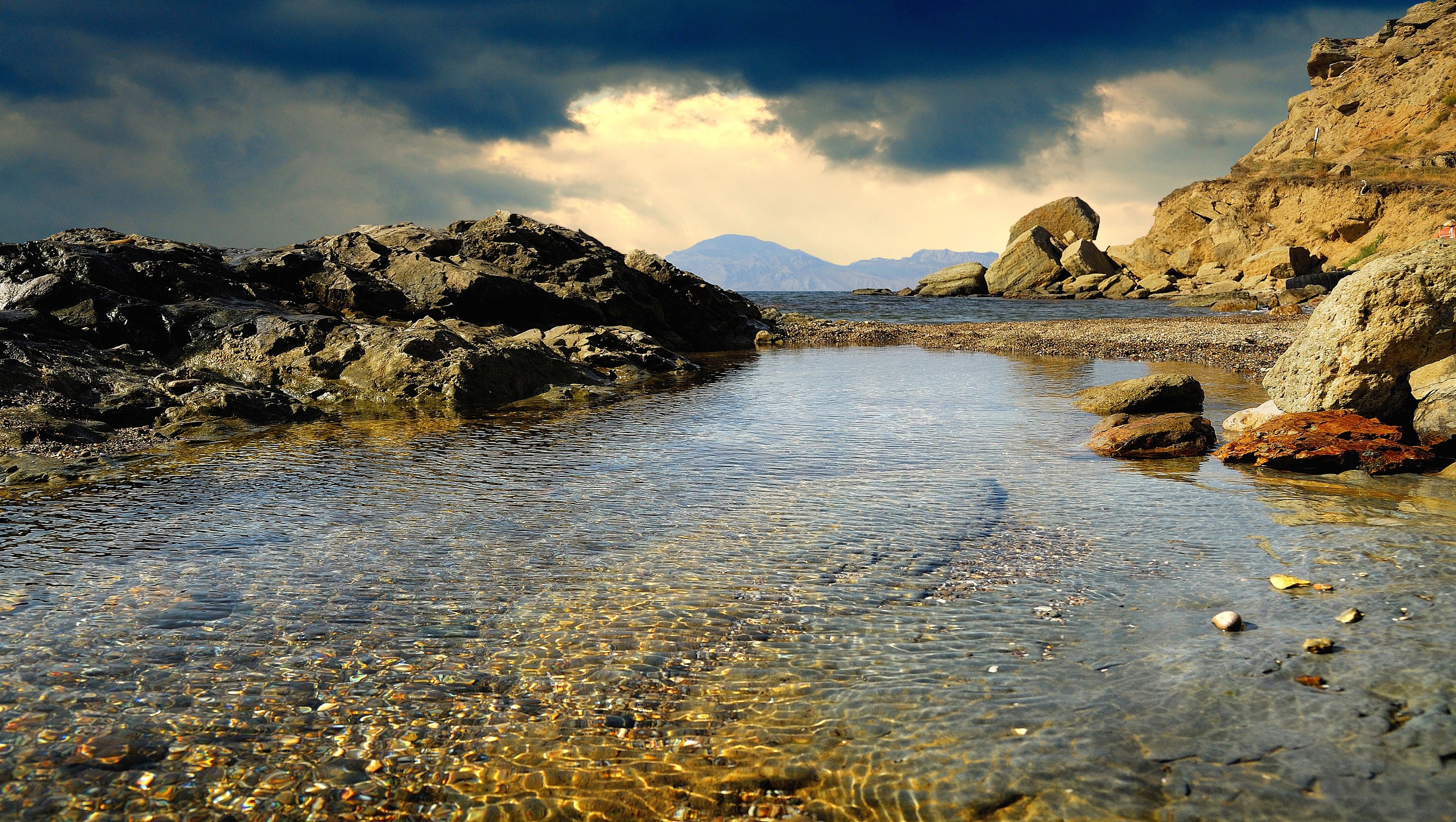 Rocky Coastline with Calm Water and Dramatic Sky HD Wallpaper