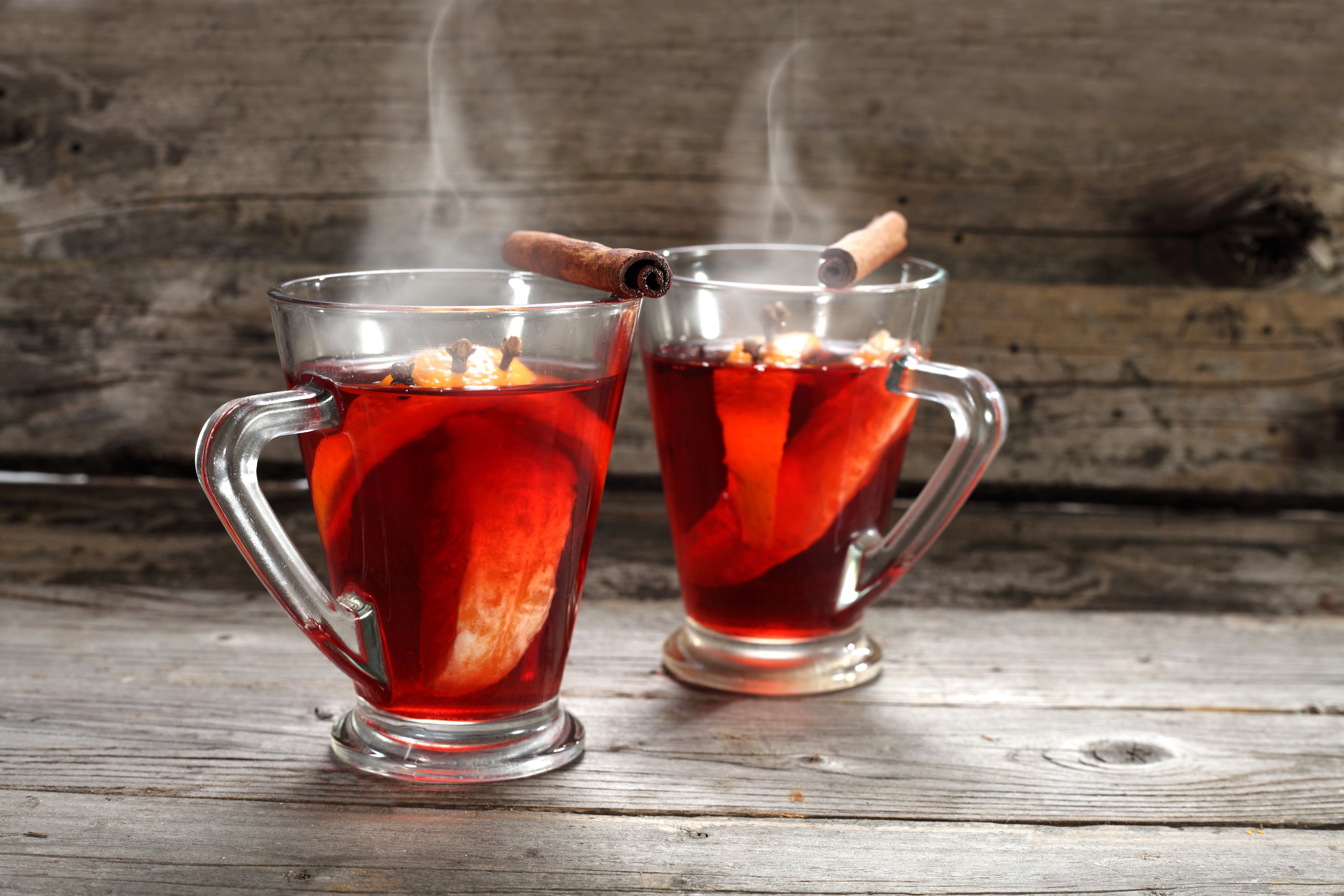 Two steaming mugs of mulled wine with cinnamon sticks HD Wallpaper