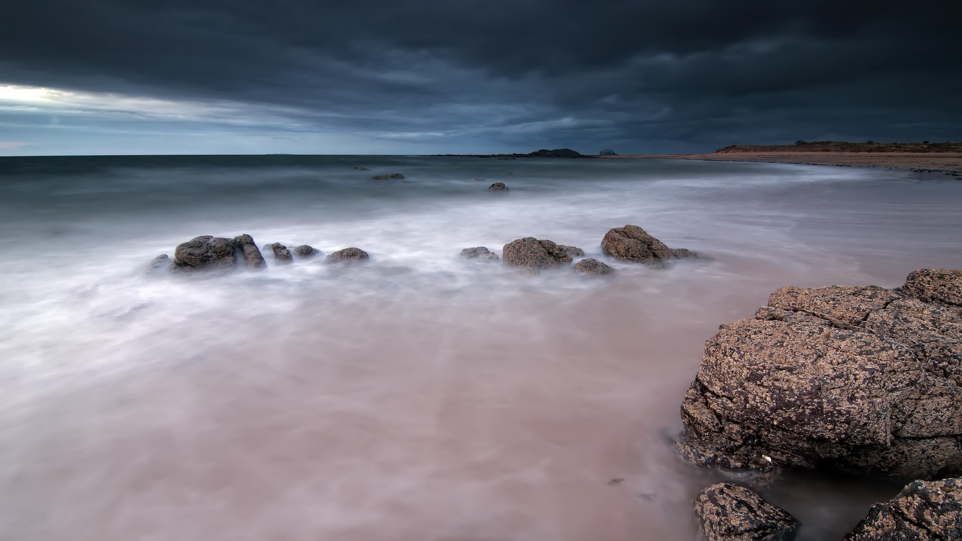 Stormy sky over a rocky beach with long exposure water HD Wallpaper