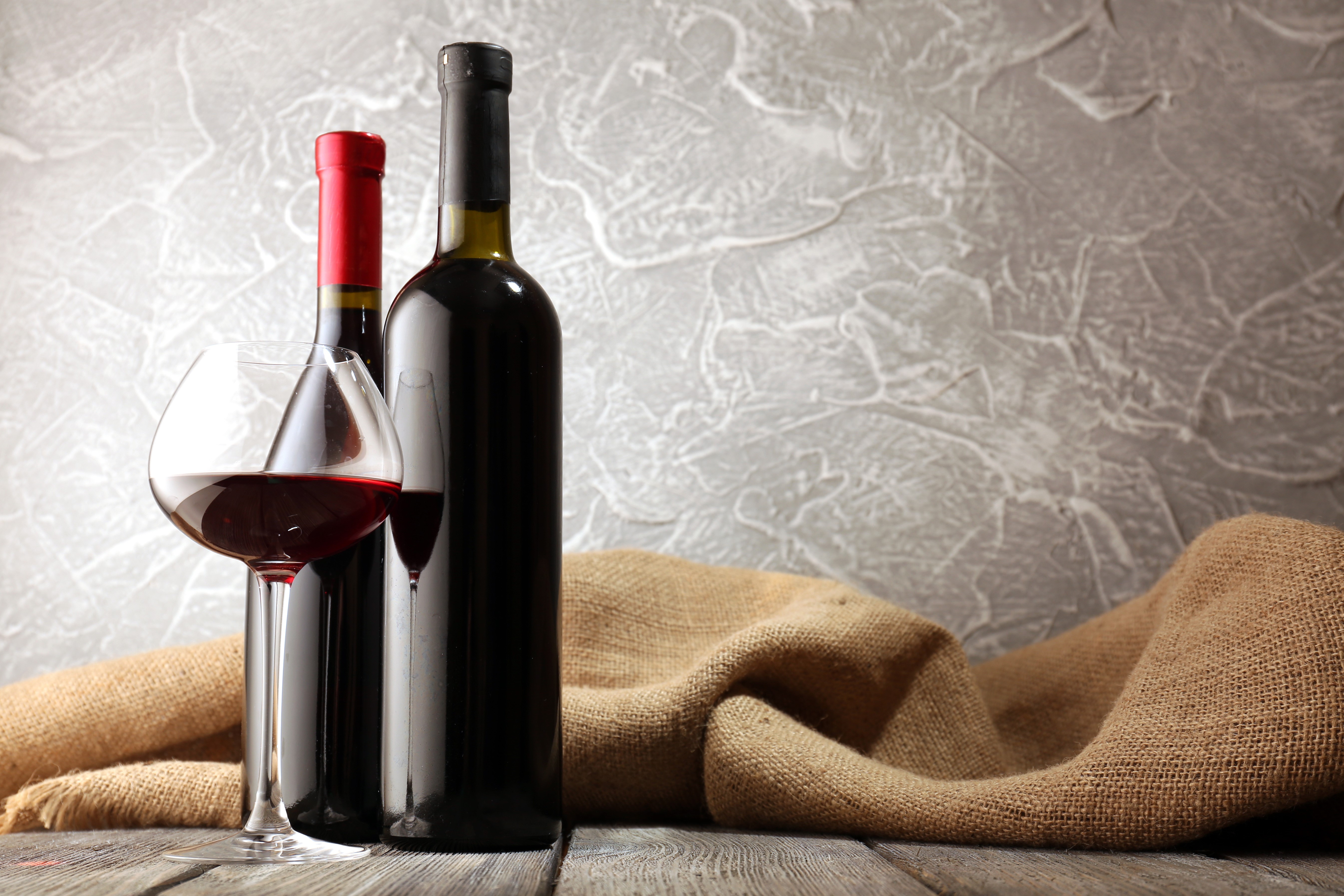 Two bottles of red wine and a glass of wine HD Wallpaper