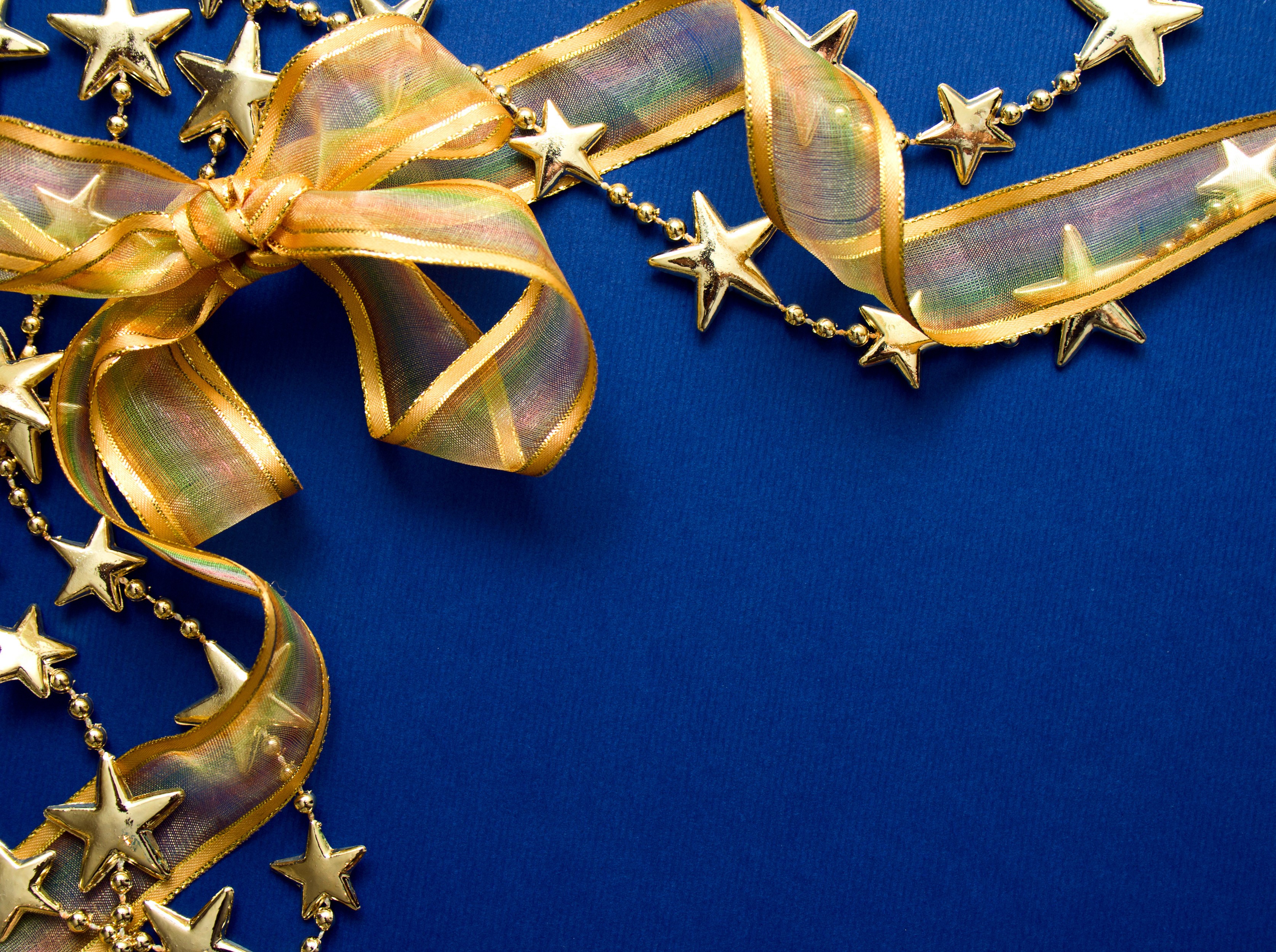 Gold ribbon and star garland on blue background HD Wallpaper