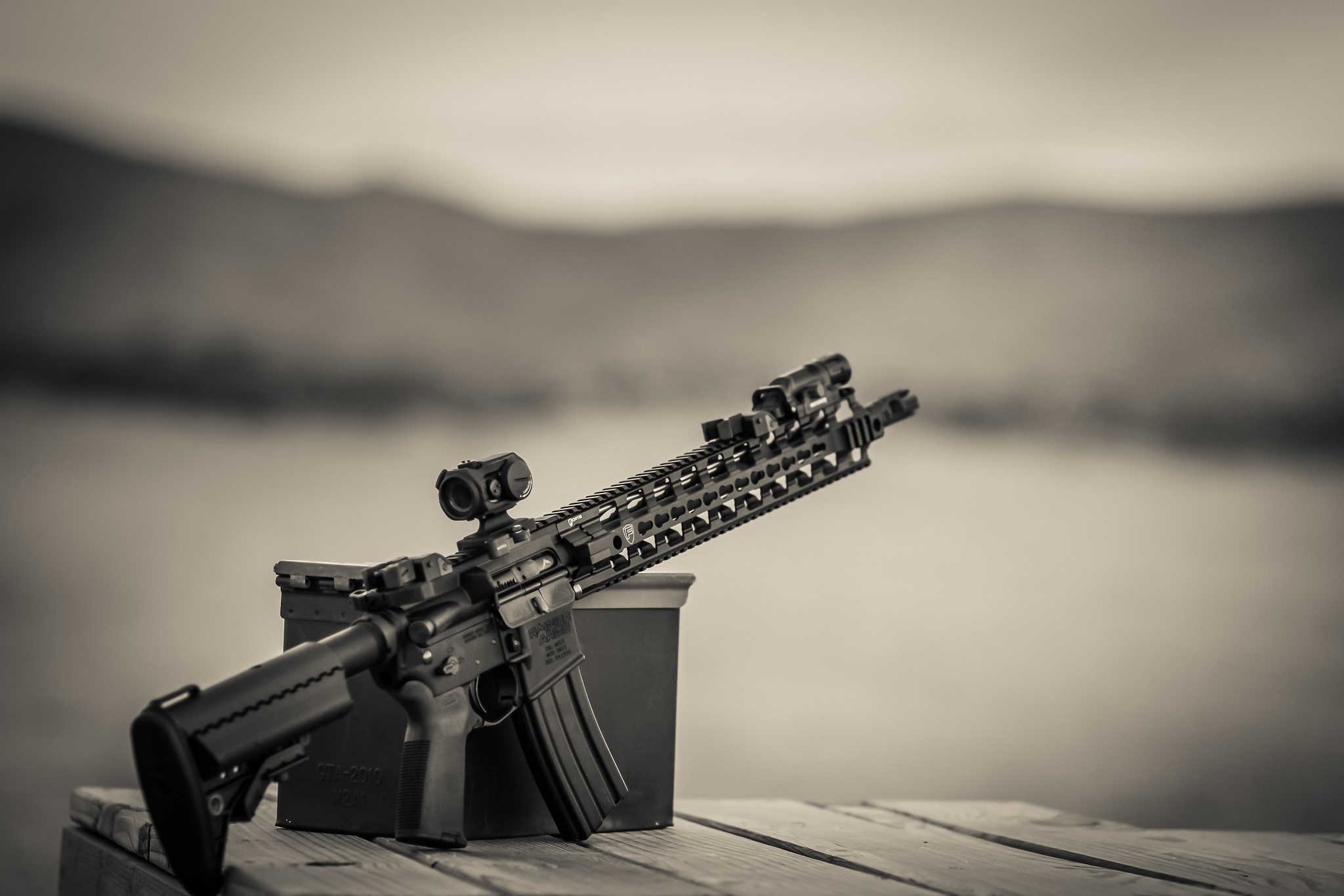 AR-15 rifle with optics on a wooden surface HD Wallpaper