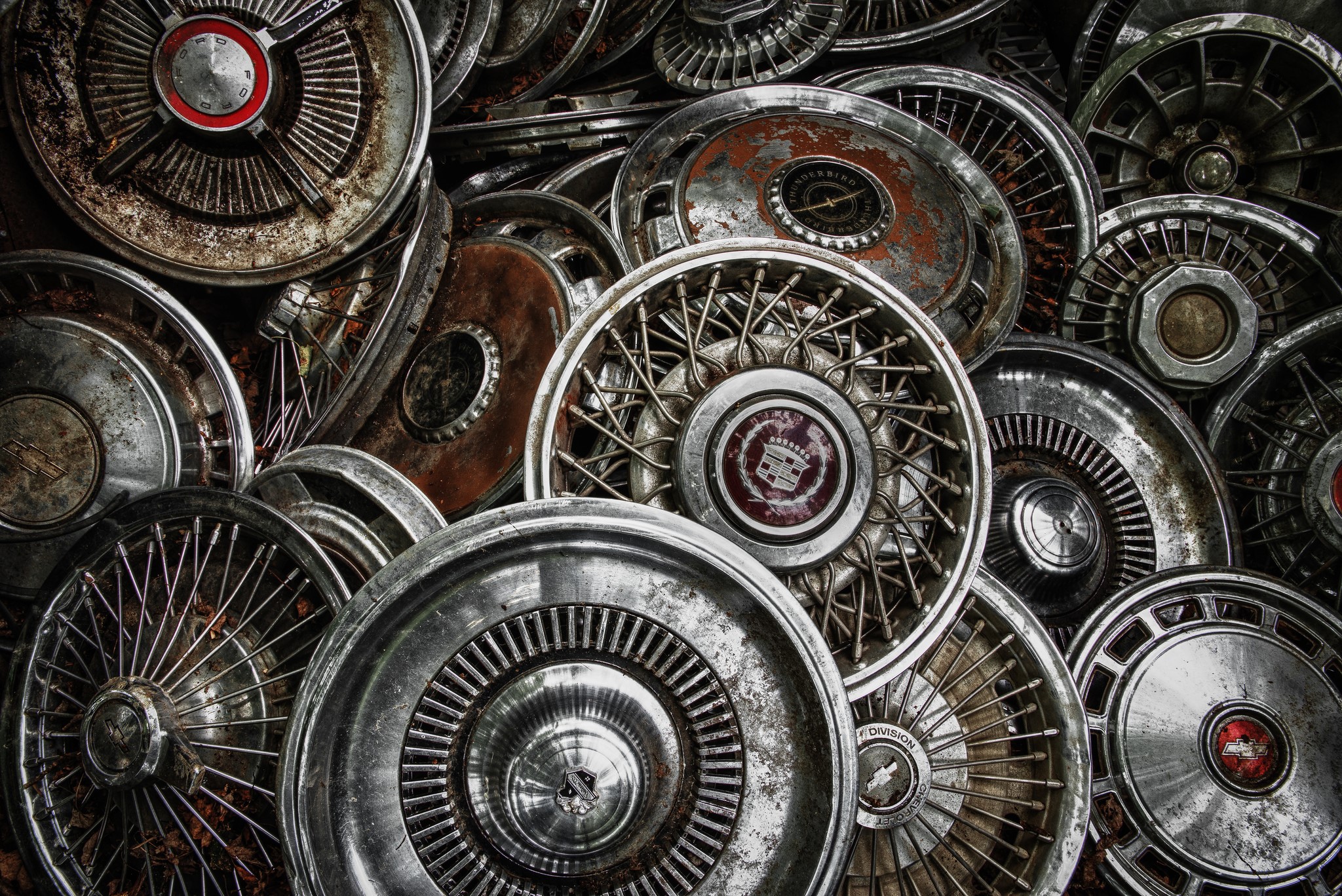 Pile of vintage car hubcaps and wheel covers HD Wallpaper