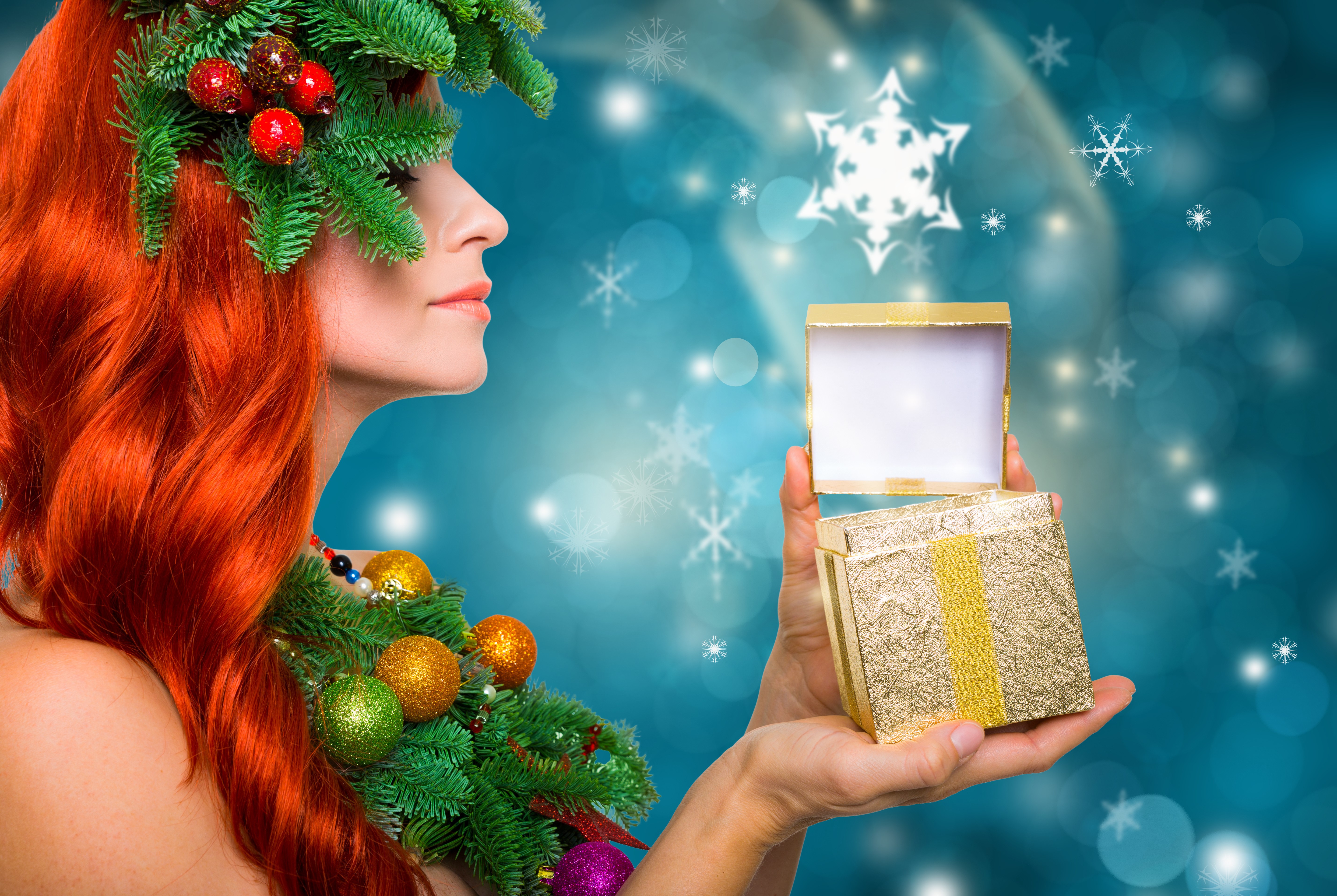 Woman with red hair and Christmas decorations opening a gift HD Wallpaper