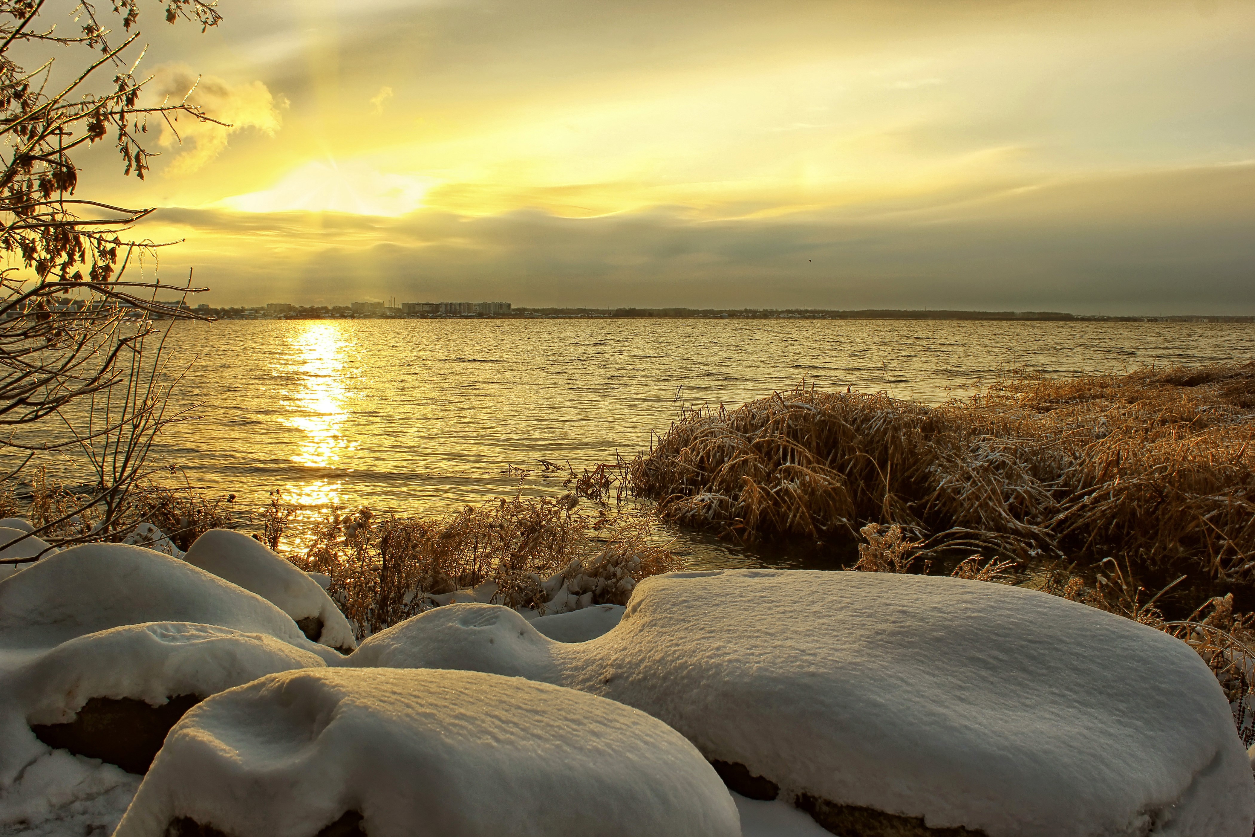 Winter sunset over a calm sea with snow-covered rocks HD Wallpaper