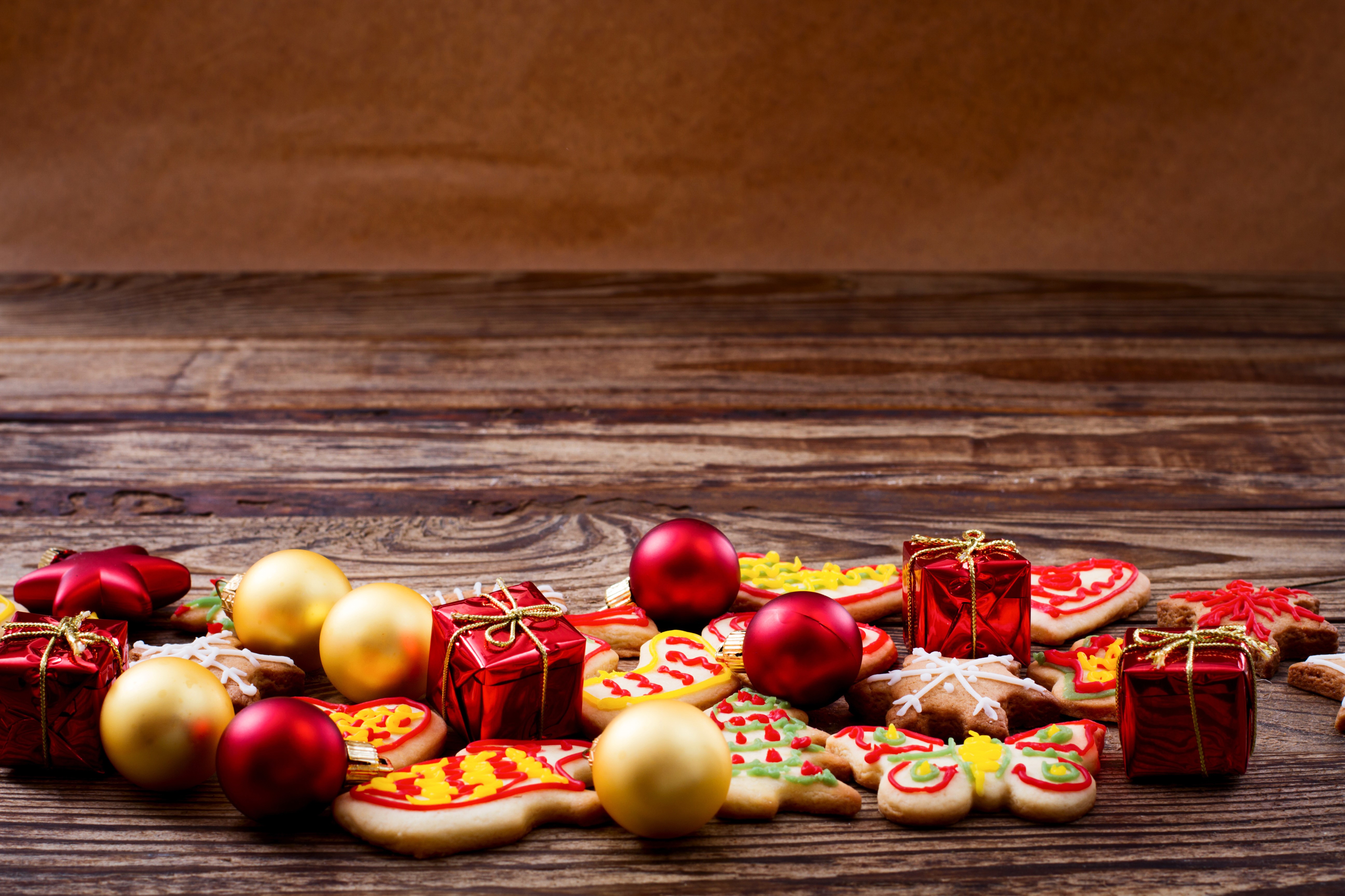 Christmas cookies, ornaments, and gifts on a wooden table HD Wallpaper