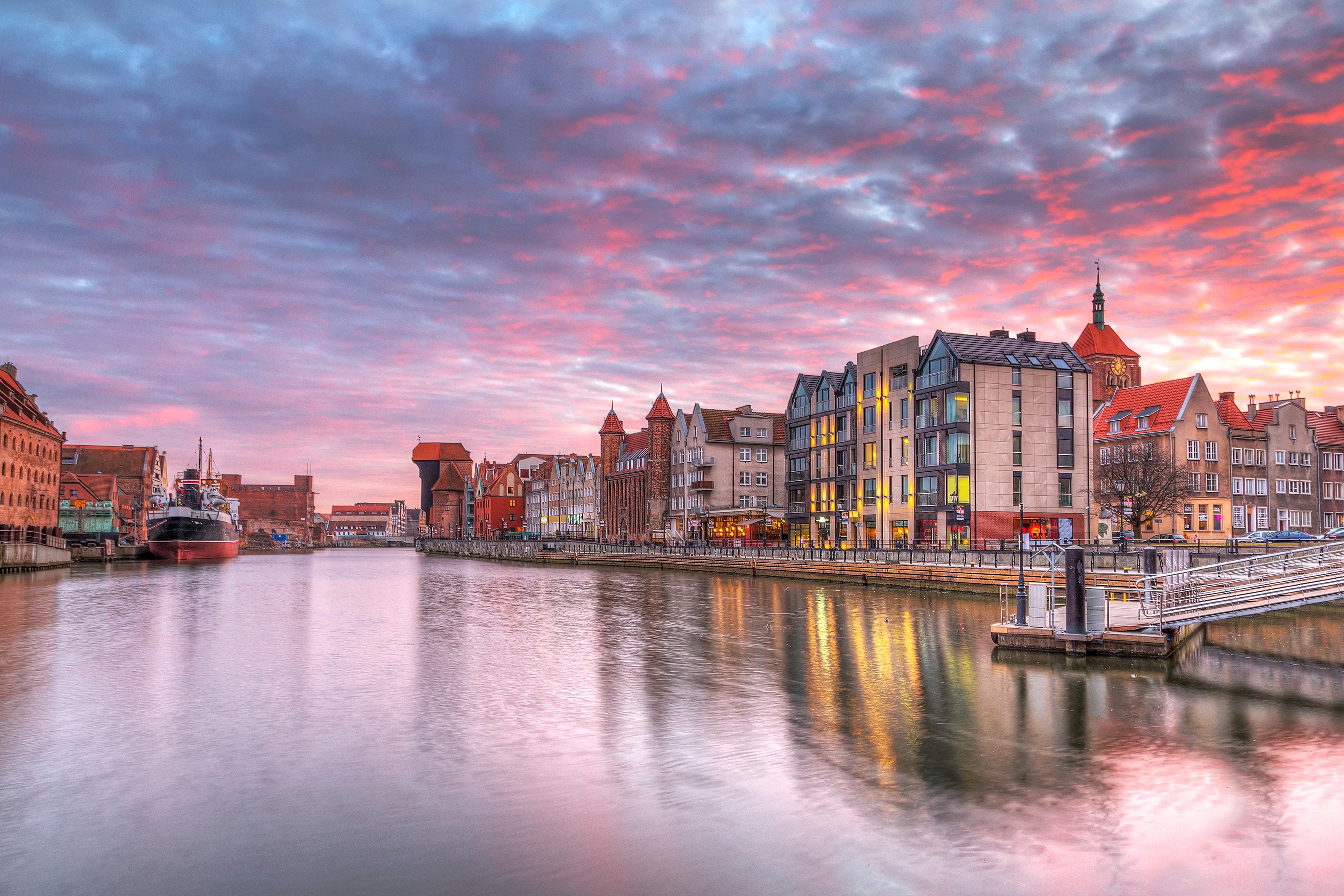 Gdańsk waterfront with historic buildings and a crane at sunset HD Wallpaper