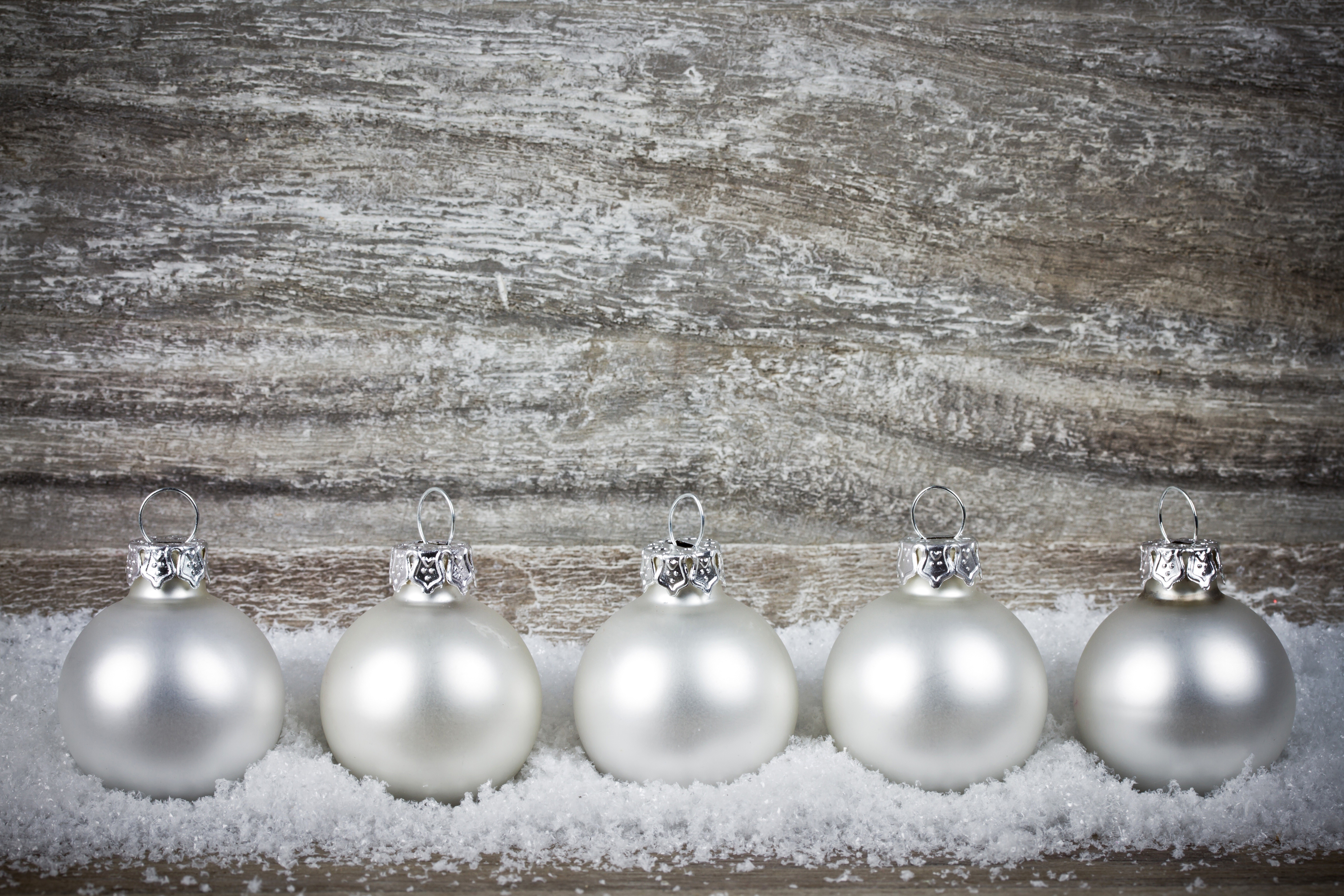 Five white Christmas ornaments on snow HD Wallpaper