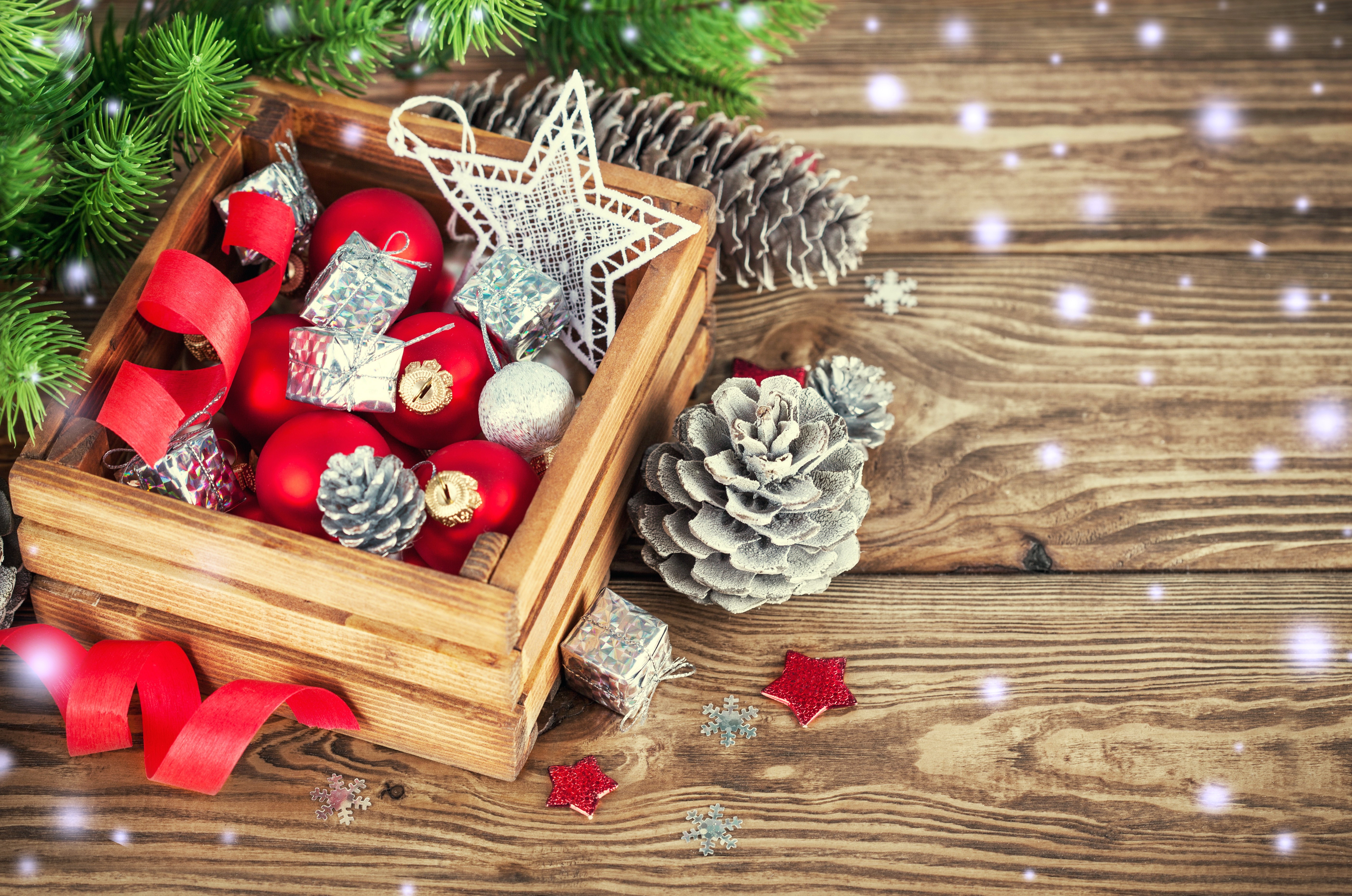 Christmas ornaments in a wooden crate with pine cones HD Wallpaper