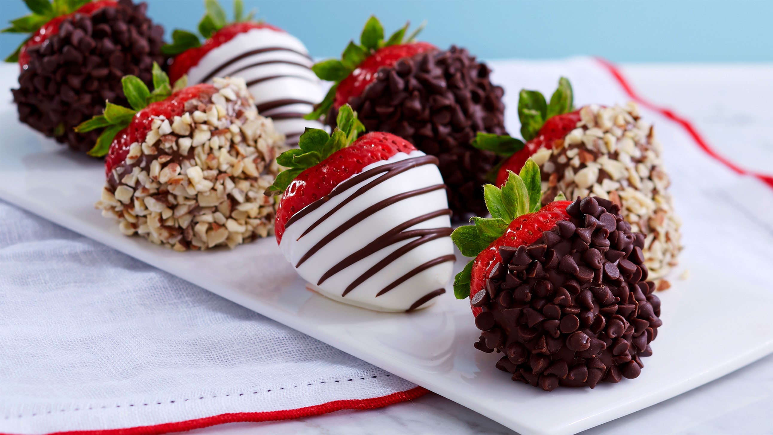 Chocolate covered strawberries with nuts and white chocolate drizzle HD Wallpaper