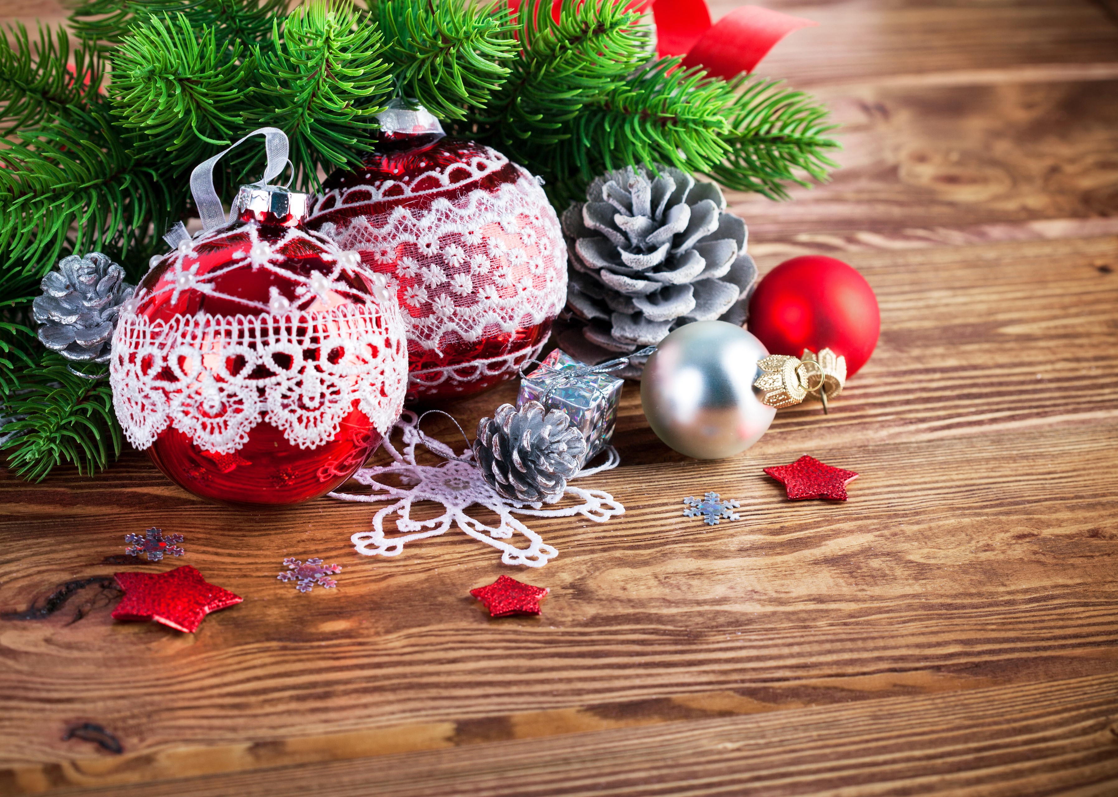 Christmas ornaments and pine cones on wooden table HD Wallpaper