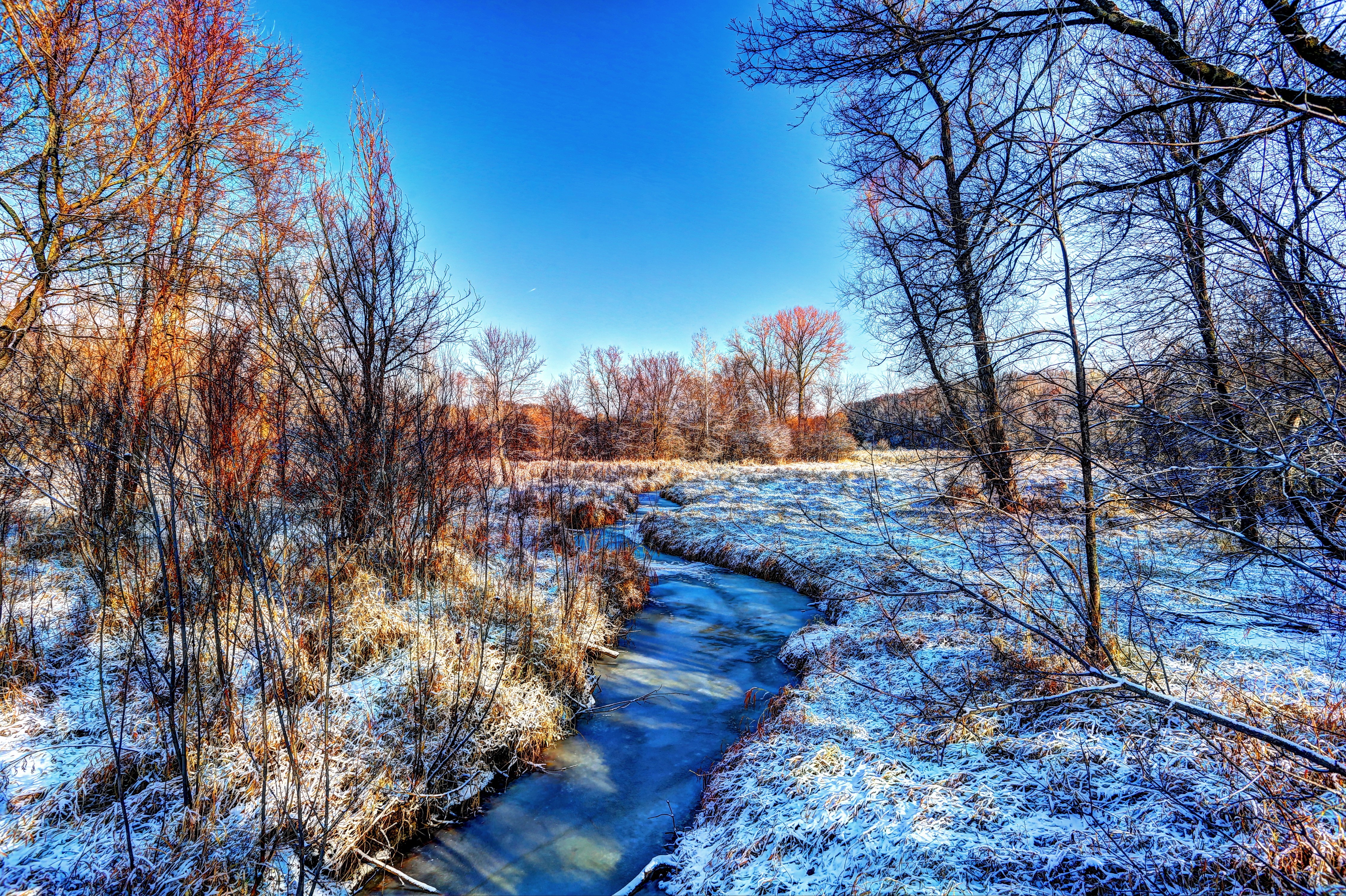 Winter scene with a frozen river and snow-covered trees HD Wallpaper