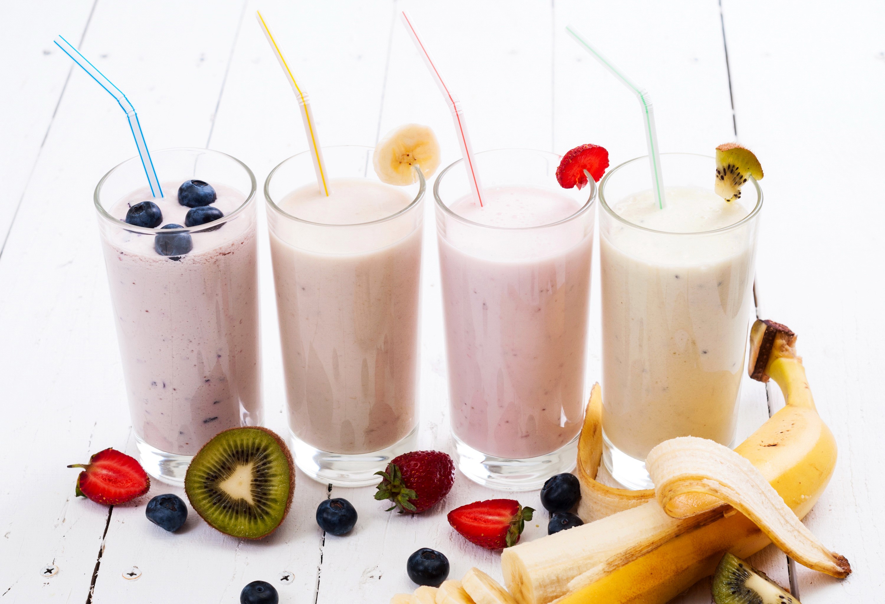 Four fruit smoothies with fresh fruit garnishes HD Wallpaper